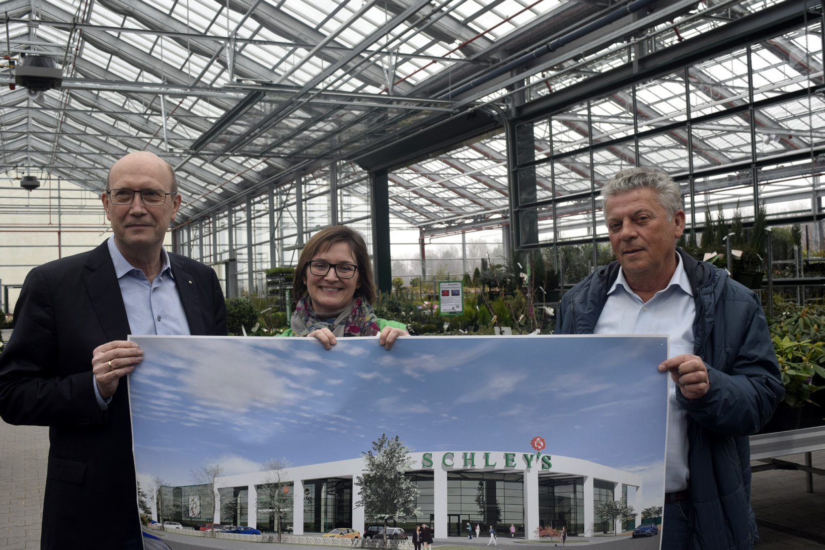 Architekt Udo Scheffler, Monika Melzer (Marketing Schley‘s Blumenparadies) und Betriebsleiter Horst Roßbach präsentieren ein Plakat mit einer Computeranimation, die zeigt, wie es am Wattenscheider Hellweg im Herbst aussehen wird. Fotos: Peter Mohr
