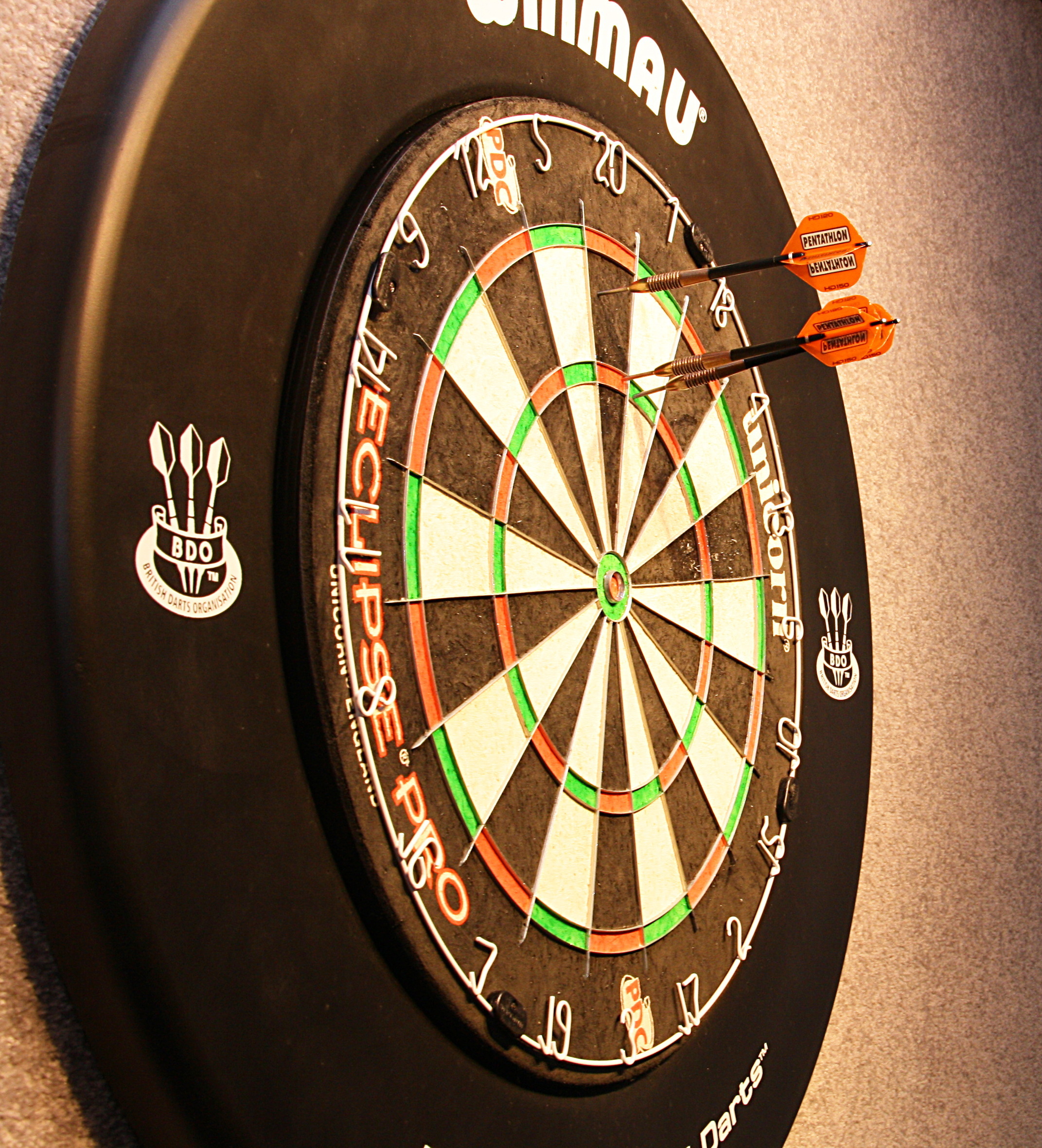 Ein Dart hat die begehrte Triple 20 getroffen, die anderen beiden Pfeile sind knapp daneben gelandet.