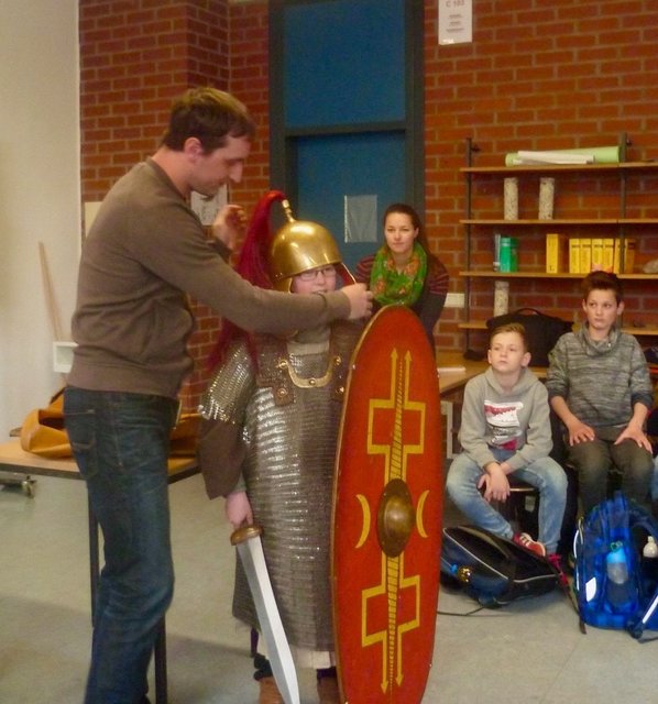 Die Aufnahmen zeigen Museumsleiter Mark Schrader und Schülerinnen und Schüler des Städtischen Gymnasiums beim Ausprobieren typisch römischer Legionärsutensilien. Fotos: Pytlinski/SGB