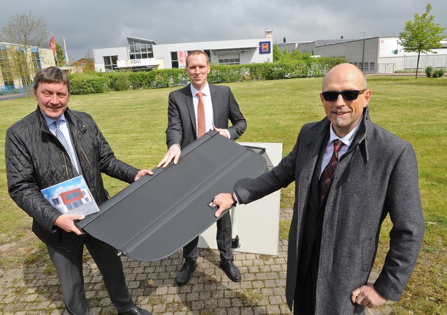 Macauto-Geschäftsführer Roger Weissmann (von rechts) zeigt Bürgermeister Dr. Jan Heinisch und Wirtschaftsförderer Peter Parnow eine Gepäckraumabdeckung für einen Audi.
