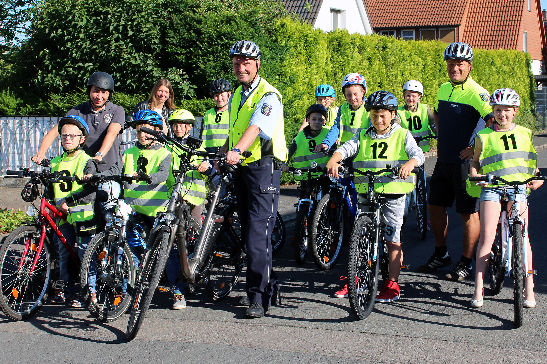 Viertklässler der Sonnenschule mit begleitenden Eltern (oben links), Polizeihauptkommissar Jürgen Horstmann und Verkehrssicherheitsberater Oberkommissar Ingo Wienecke