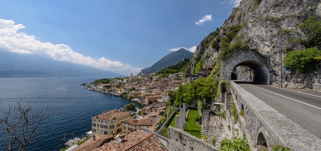 Panorama-Aufnahme, auf der die Lage von Limone zwischen Bergen und See deutlich wird; rechts die Uferstraße "Gardesana"