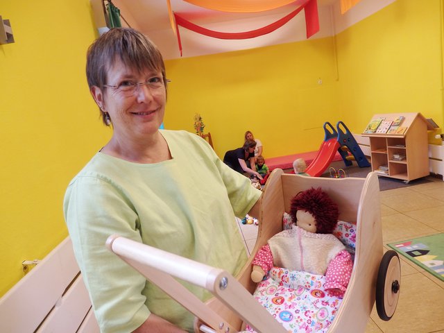 Erzieherin und plus-Kita-Kraft Annette Höfer mit dem neu angeschafften Puppenwagen, der der Renner bei den Kindern ist. Pressefoto: Kirchenkreis Essen/Stefan Koppelmann