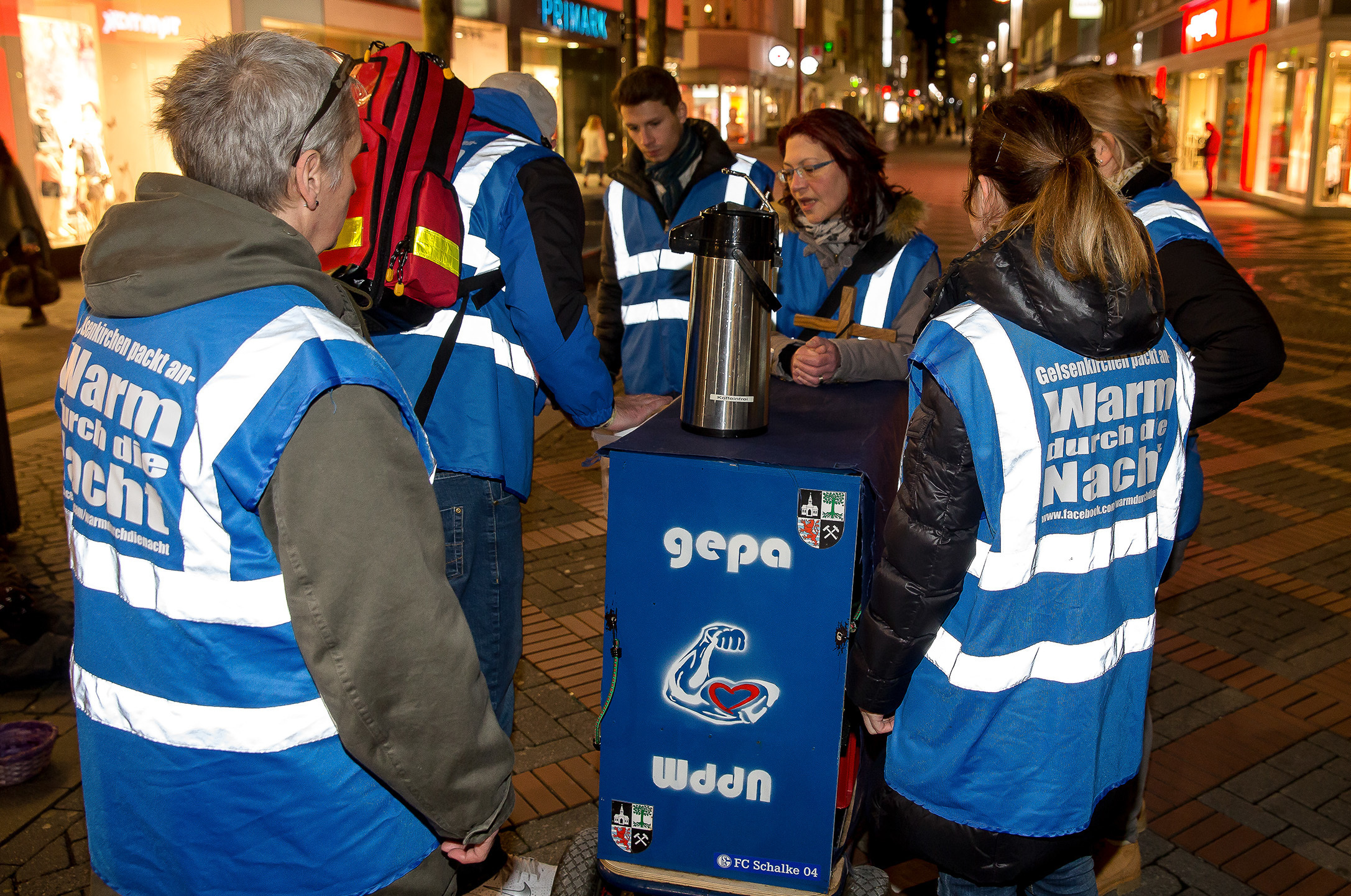 Mit ihrem Bollerwagen ziehen die an ihren blauen Westen mit dem weißen Schriftzug „Gelsenkirchen packt an! - Warm durch die Nacht“ gut zu erkennenden Mitstreiter des Vereins kurz nach Ladenschluss durch die Innenstadt, um die Bedürftigen zu versorgen. Foto: Gerd Kaemper