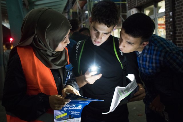 Rabia Yurdagül (links) erklärt den Jugendlichen den Busfahrplan.