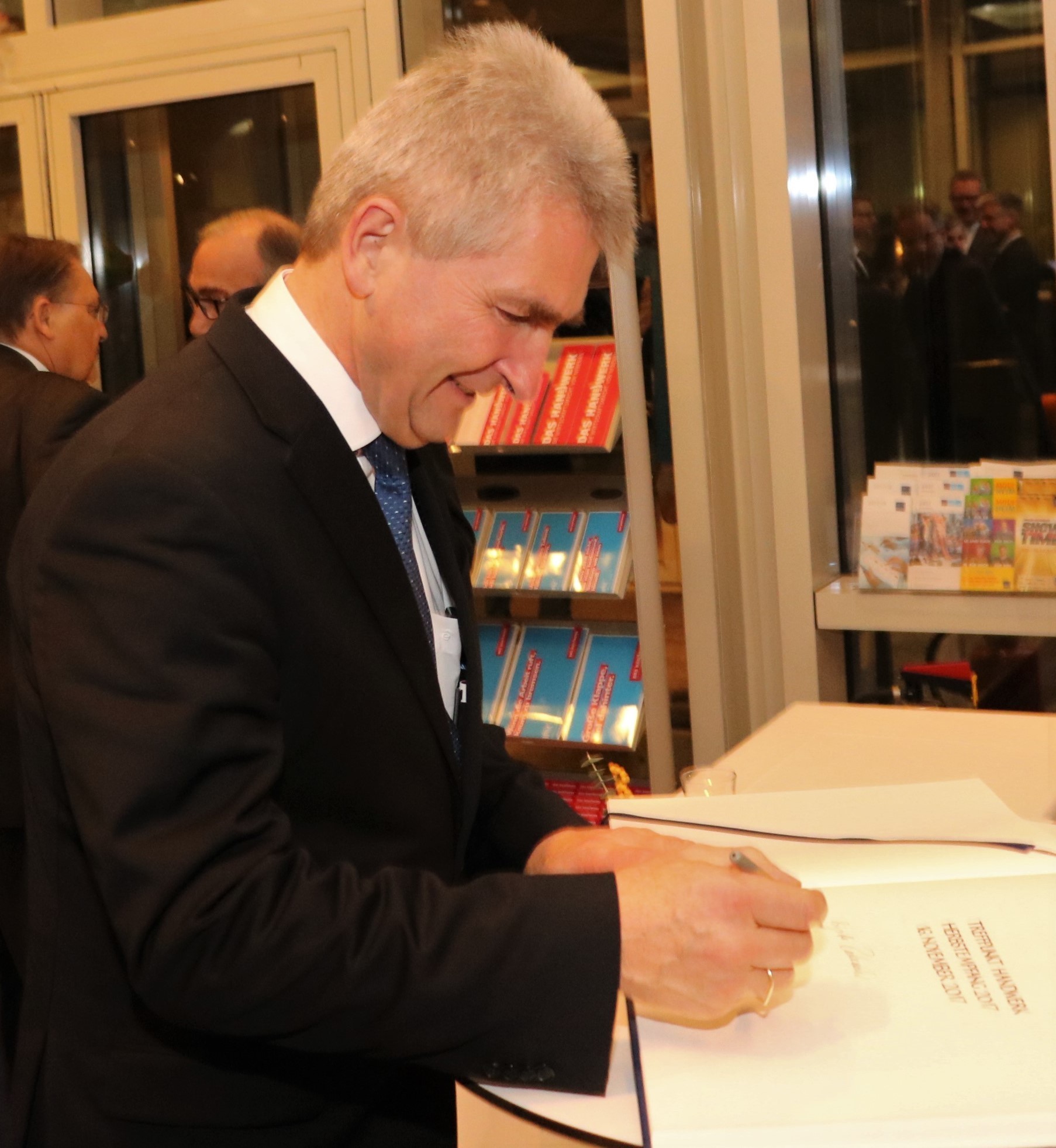 Minister Pinkwart trägt sich ins Goldene Buch der Handwerkskammer ein.