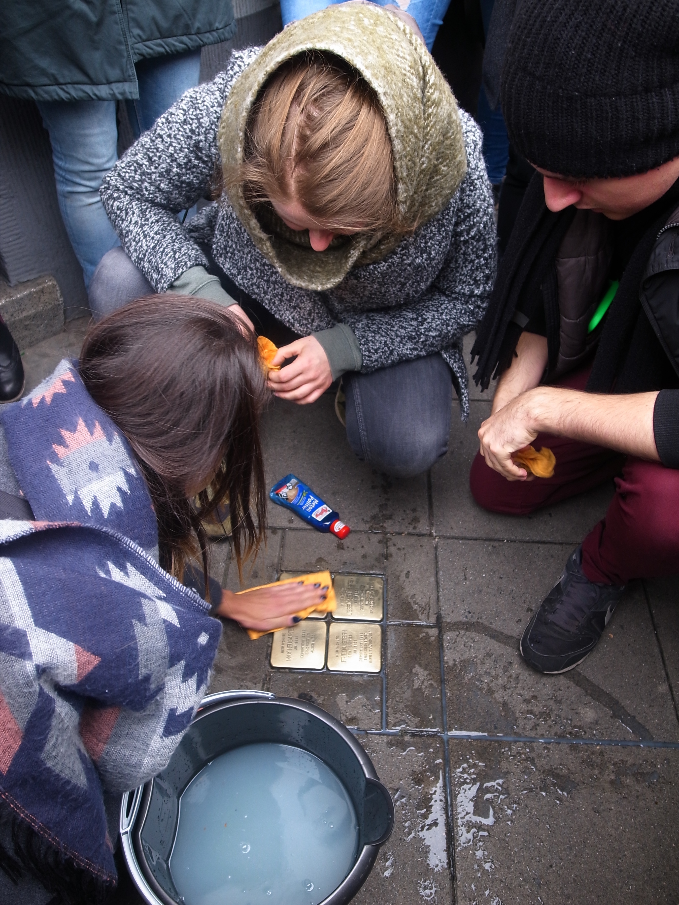Studierende putzen die Stolpersteine an der Rheinischen Straße