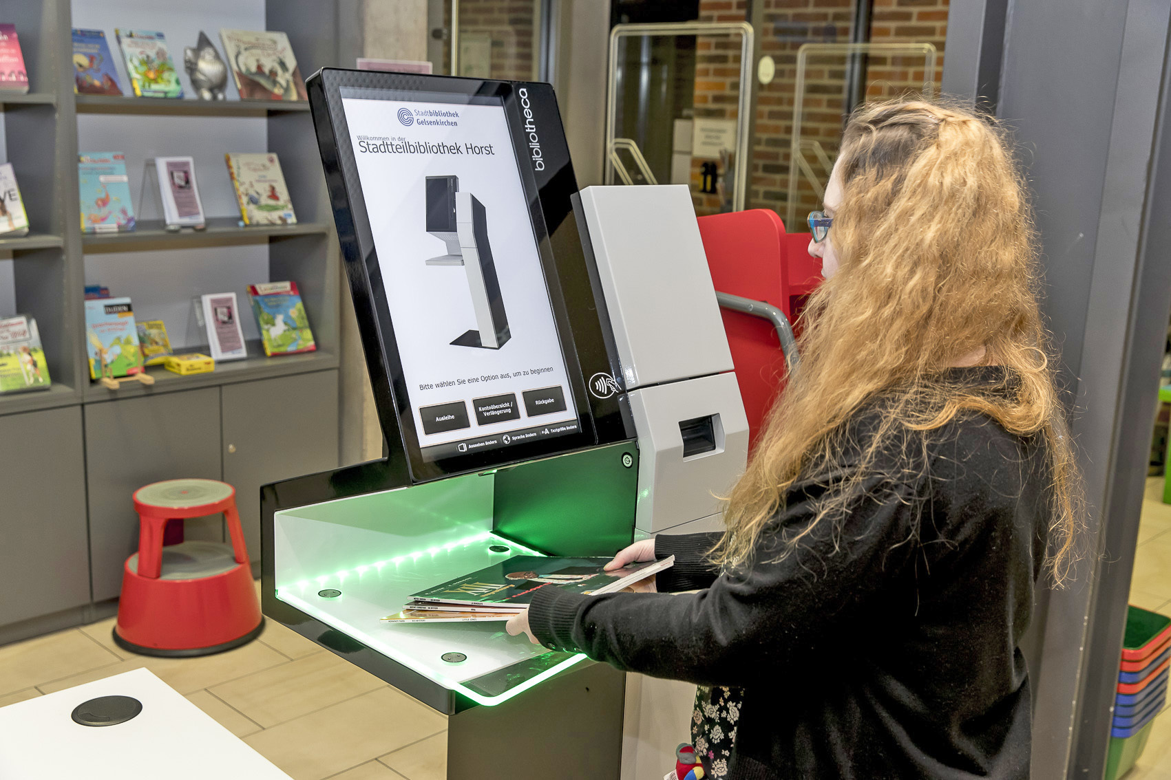 Dank der neuen Verbuchungstechnologie können die Kunden ihre Medienausleihe eigenständig verwalten. Die Geräte ermöglichen Ausleihe und Rückgabe der Medien in einfachen Schritten. Das Foto zeigt die Ausleihe in der Stadtteilbibliothek Horst. Die Bibliotheken werden derzeit schrittweise auf die neue Technik umgerüstet.