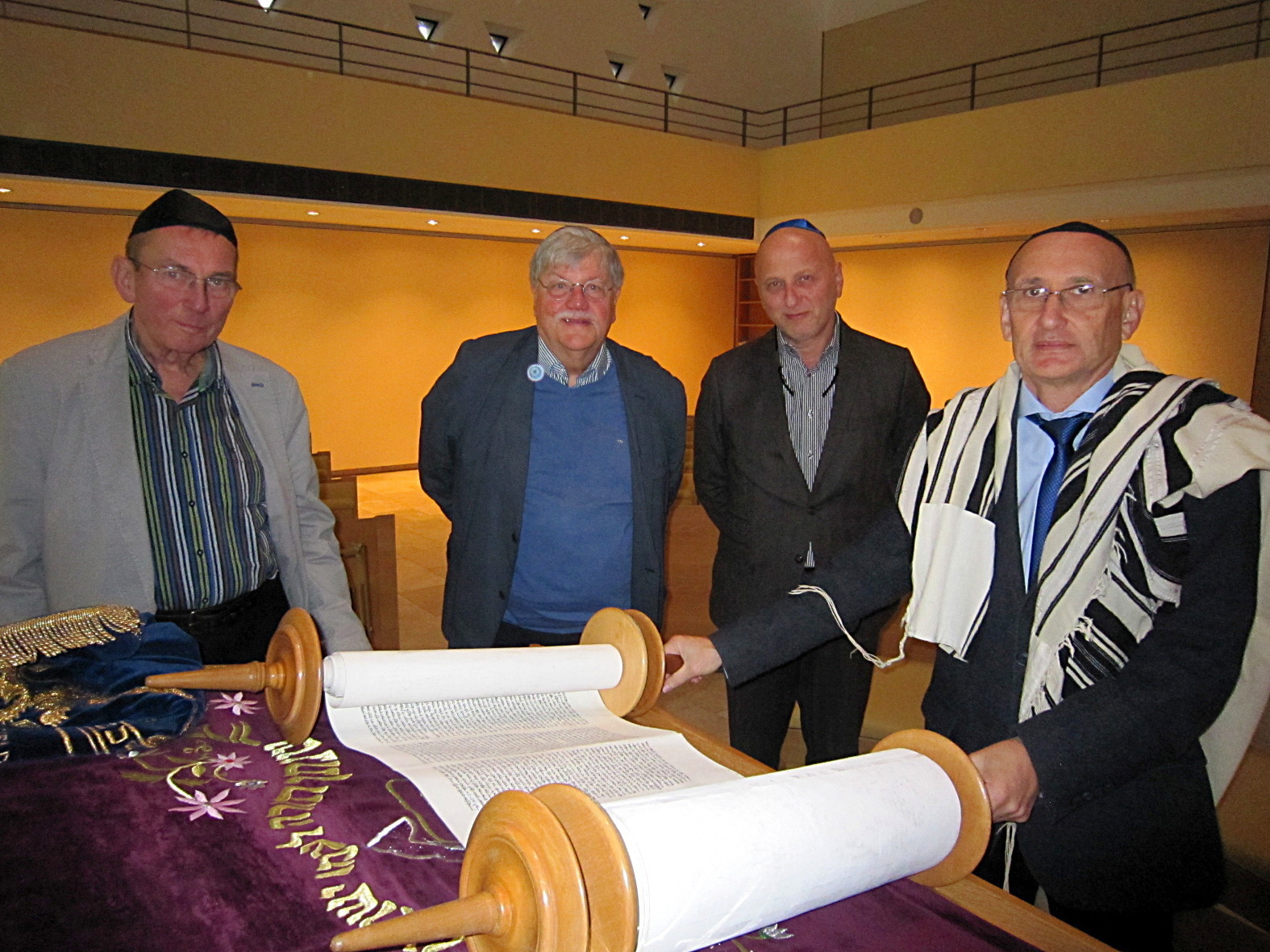 Gerd Liedtke (v.l.), Ehrenvorsitzender des Freundeskreises Bochumer Synagoge, der erste Vorsitzende Dr. Volker Brüggemann, Aleksander Chraga, Geschäftsführer der Jüdischen Gemeinde Bochum-Herne-Hattingen, und der Vorstandsvorsitzende Grigory Rabinovich mit einer der vorhandenen gebrauchten Thorarollen.