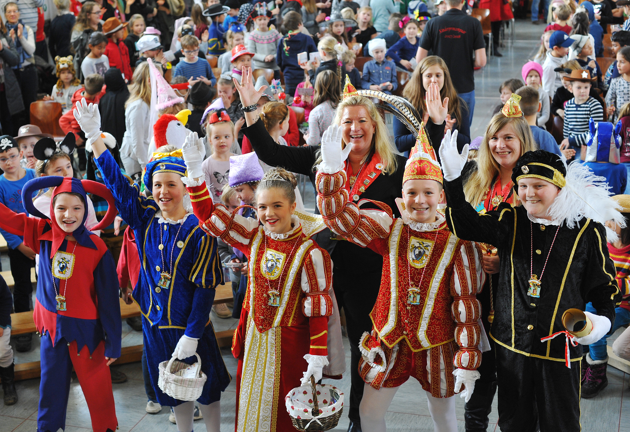 Premiere gelungen: An der Seite der Gromoka-Kinderprinzenführerinnen Biggi Donath (hinten links) und Vanessa Klein (hinten rechts) und umgeben von hunderten Schulkindern absolvierten Prinzenpaar und Gefolge die Proklamation in der Turnhalle der Lottenschule.