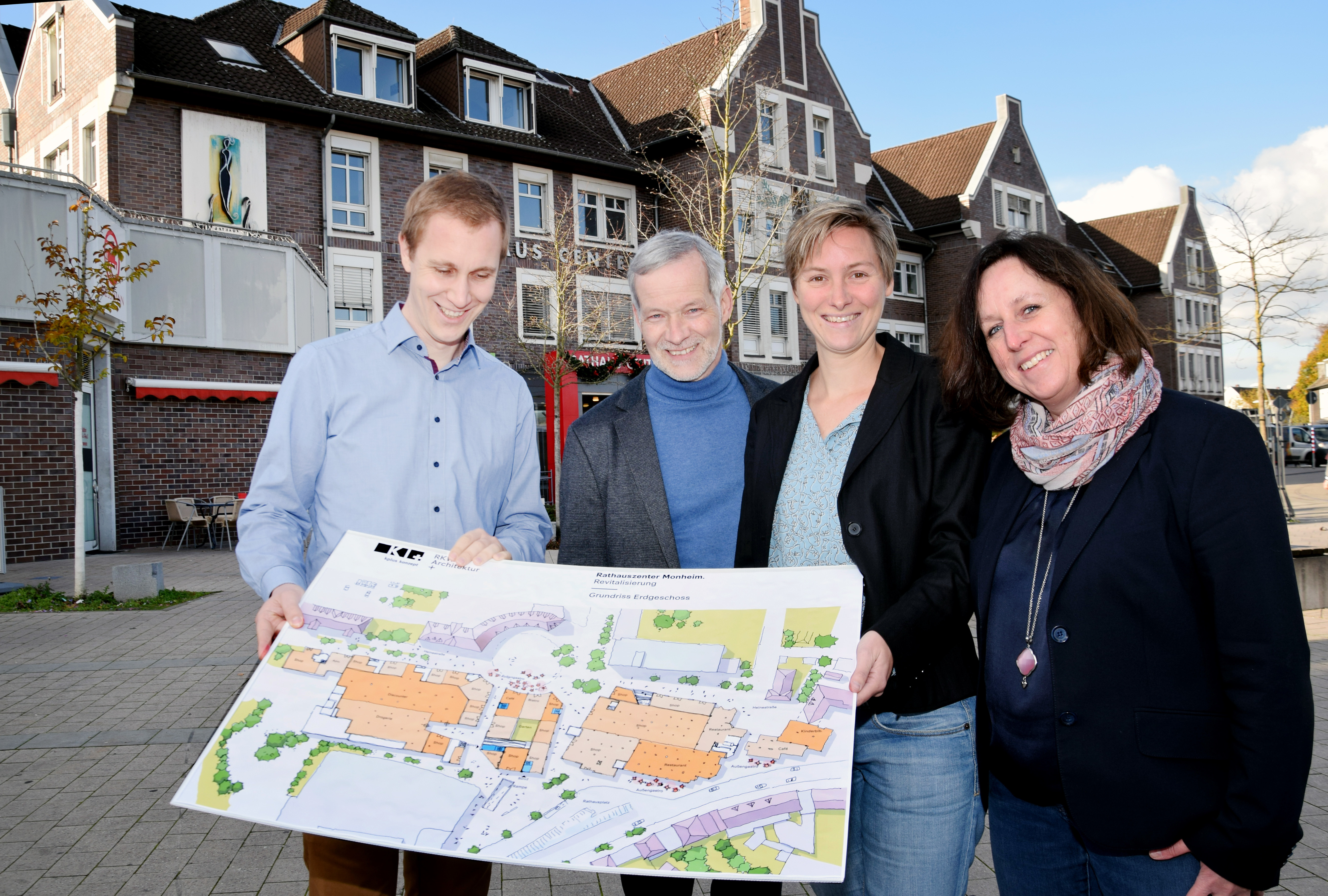 Bürgermeister Daniel Zimmermann, Stadtplanungschef Thomas Waters sowie Estelle Dageroth und Isabel Port aus der Stadtmarketing-Abteilung mit den künftigen Plänen für das Monheimer Rathaus-Center.