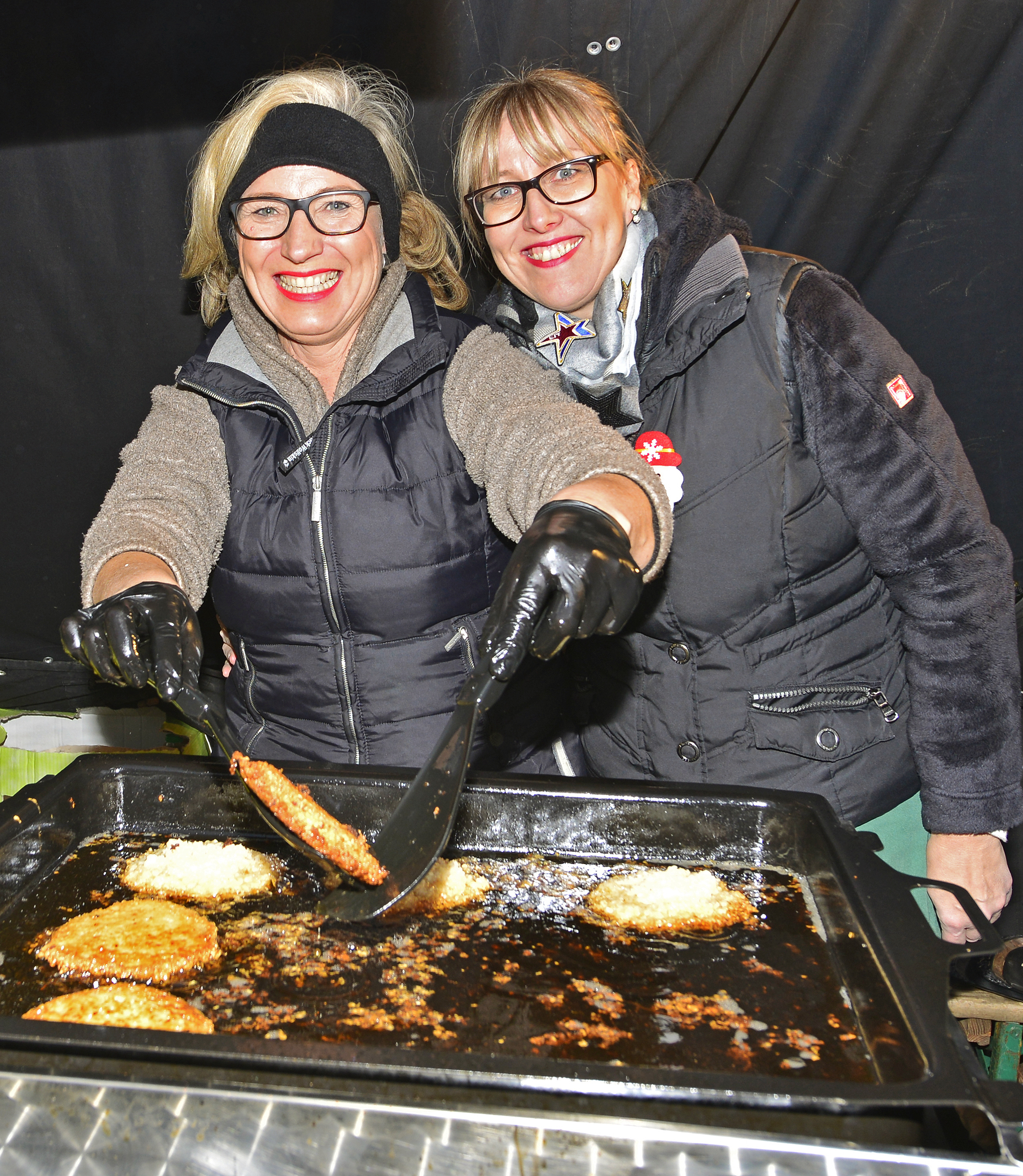 Frisch aus der Pfanne: Mit viel Liebe gebacken und heißen Reibekuchen jonglieren hier Maria Makowka und Sandra Sump auf dem Adventmarkt und Kirchenvorplatz der St. Josef-Gemeinde zum Wohl der Besucher, die zahlreich erschienen waren. Foto: Kariger