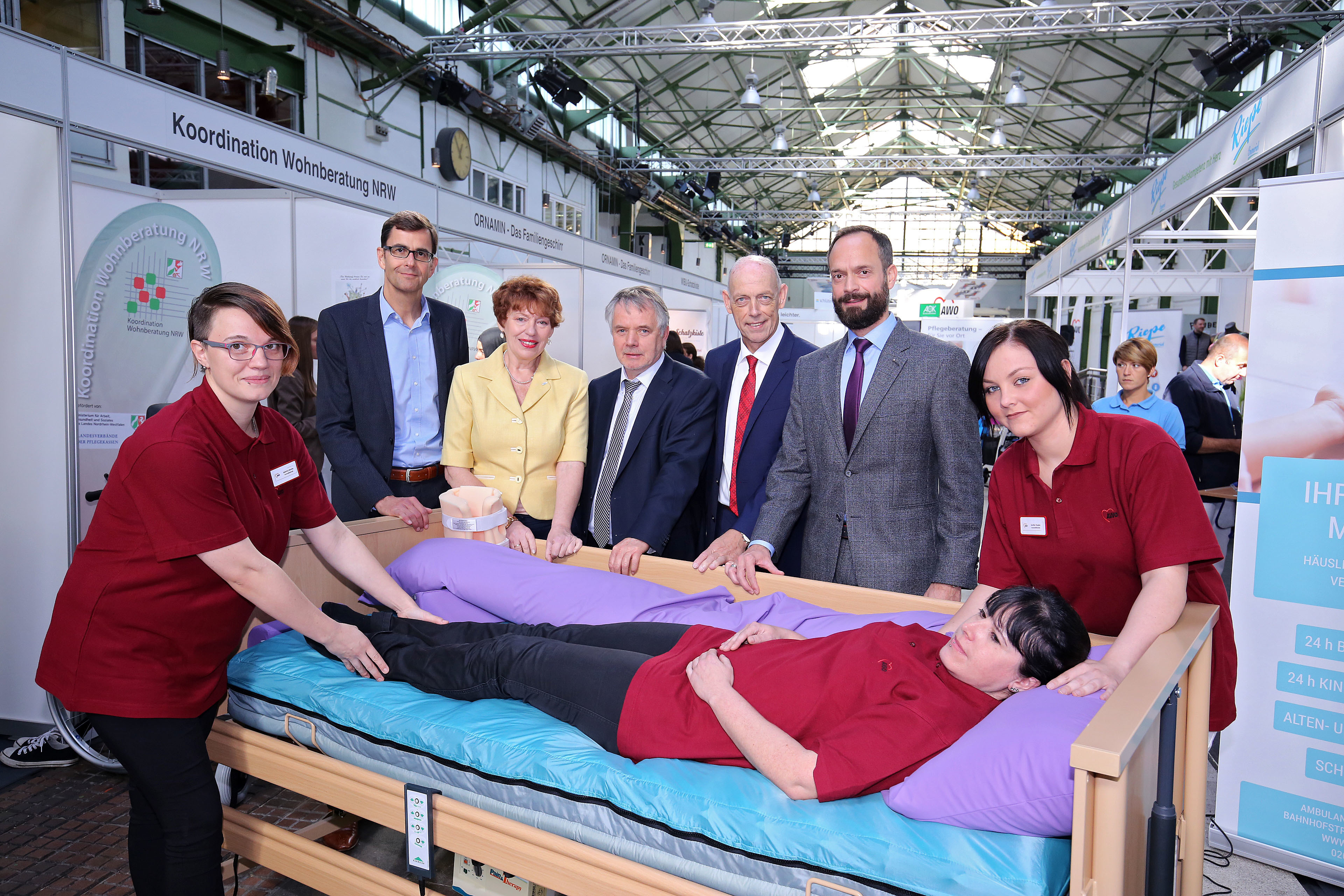 Die drei Auszubildenden der AWO (v.l.) Sabrina Reiche, Sabrina Bollow und Jenifer Dupke demonstrieren den Organisatoren des Deutschen Pflegetages on Tour im Depot (v.l.) Lutz Bandte, Irene Meier, Reinhard Strüwe, Klaus Steenweg und Tom Ackermann Handgriffe in der Pflege von Angehörigen.
