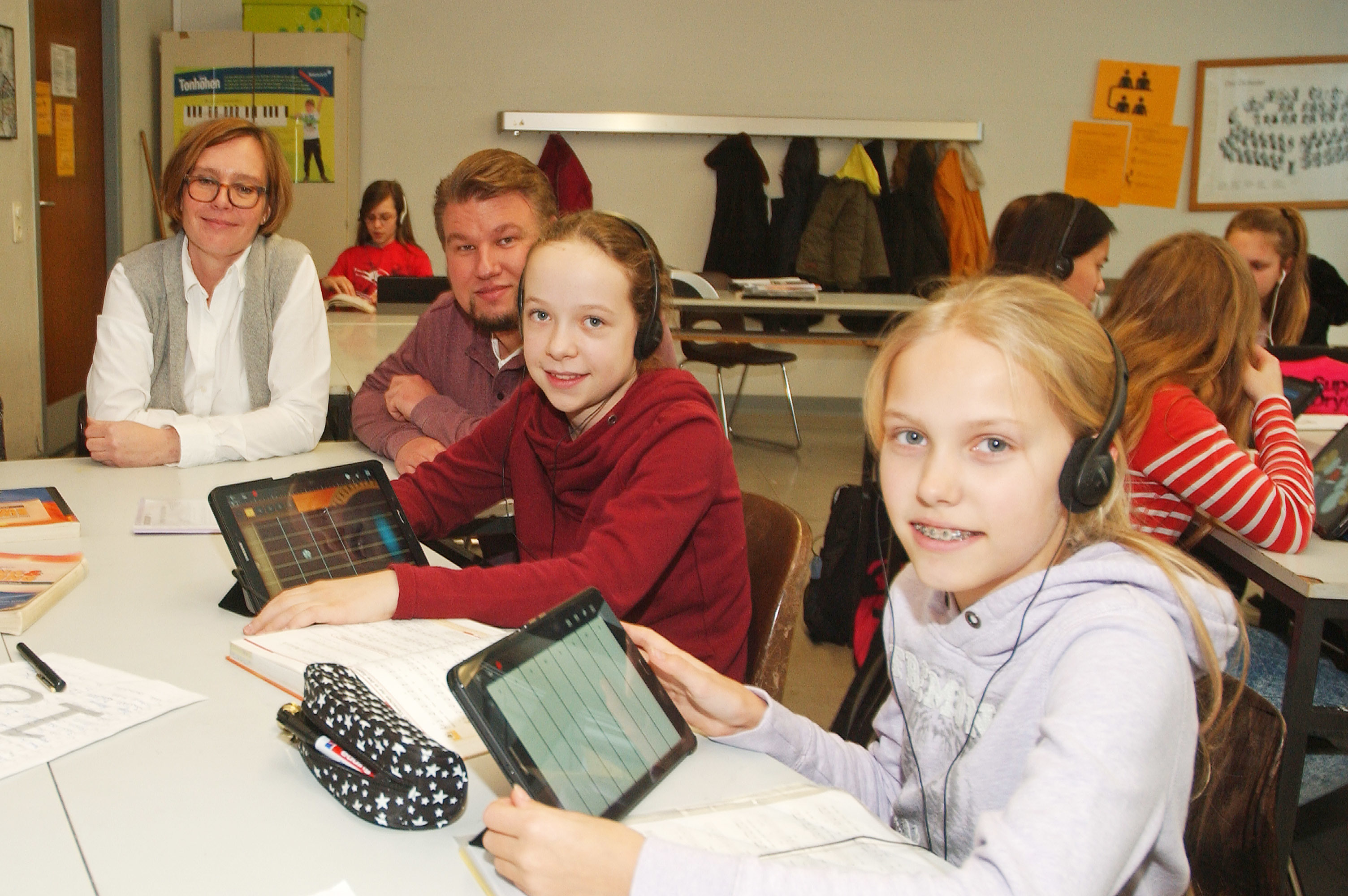 Anna (rechts) und Finja arbeiten begeistert im Musikunterricht mit den Tablets und werden dabei von Steffen Wardemann, der die Idee zum Projekt hatte, und Amelie Krüger unterstützt.