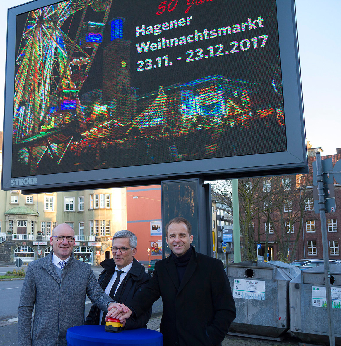 Oberbürgermeister Erik O. Schulz (Mitte), Alexander Stotz, CEO der Ströer Media Deutschland GmbH (rechts), und Thomas Lehner (Leiter der Niederlassung Wuppertal der Ströer Media GmbH) vor dem Hinweis auf den Jubiläumsweihnachtsmarkt in der City.