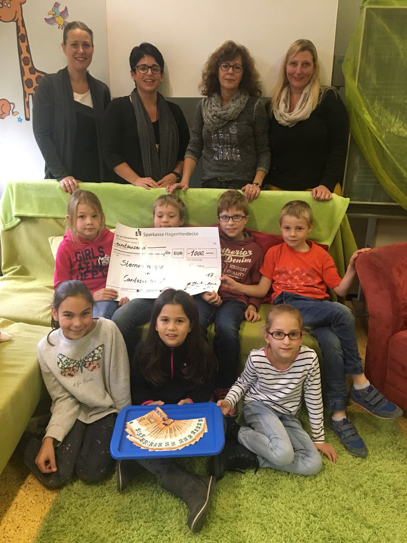 Das Foto zeigt (stehend, von links nach rechts): Henrike Beckenbach (Schulleiterin), Ulrike Söth (Caritas), Sylvia Labitzke (stellv. Schulleiterin), Yvonne Meyer (Schulpflegschaftsvorsitzende), vorn: die Klassensprecherinnen und Klassensprecher der Klassen 2-4.
