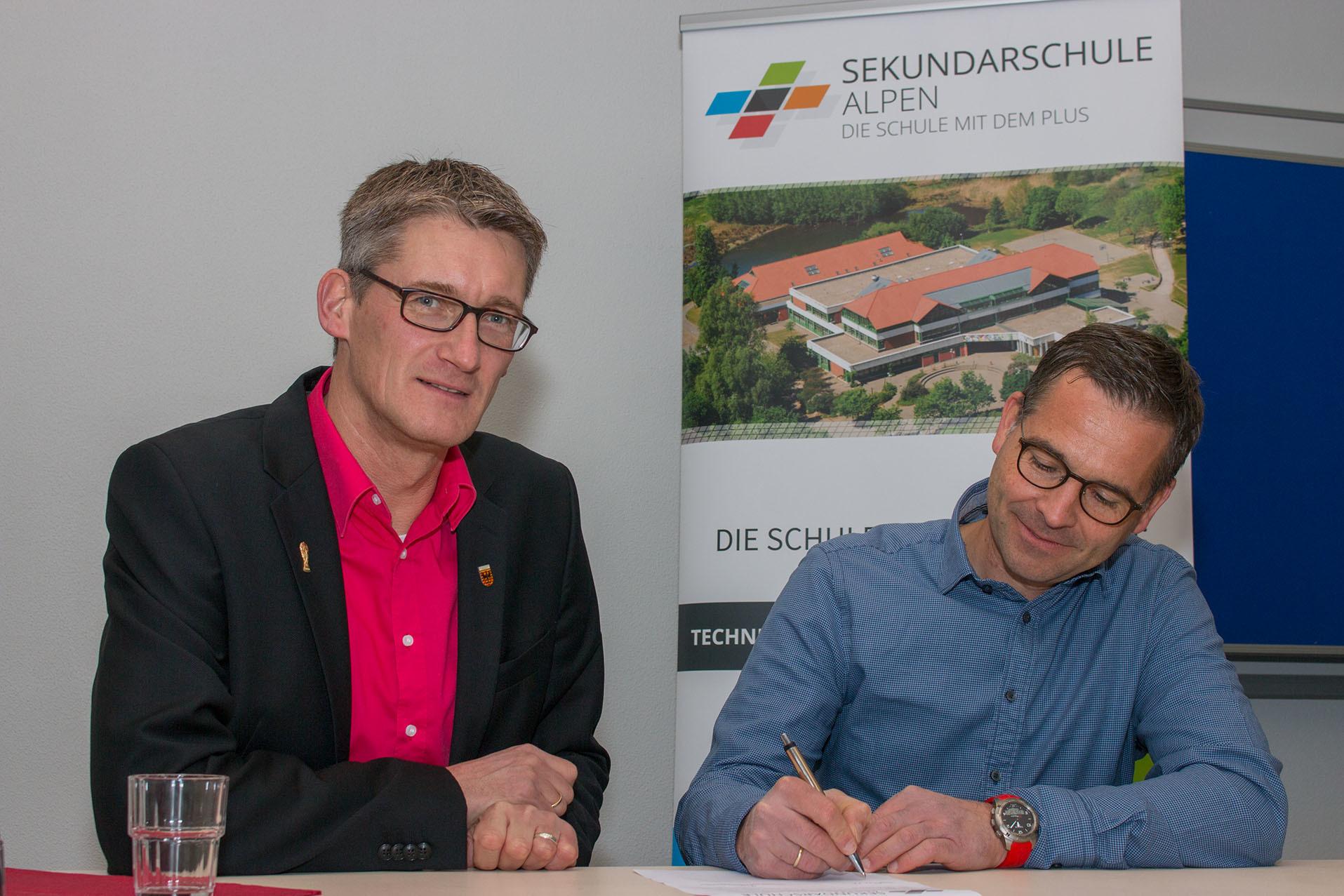 Schulleiter Tilman Latzel und Thomas Luft von Edeka Luft beim Unterzeichnen des Kooperationsvertrages