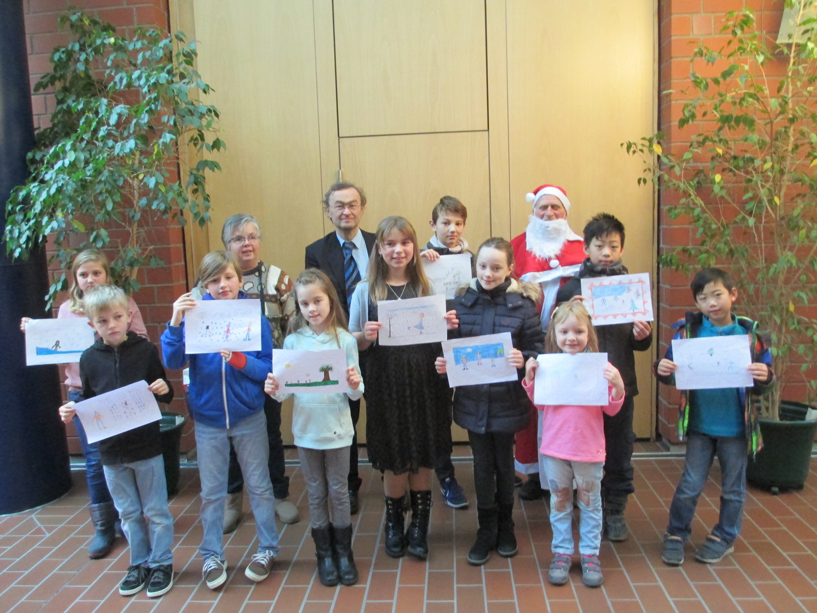 Ute Backenstoss (Jugendbeauftragte), Ewald Zmarsly (Erster Vorsitzender) und Günther Eschrich (Nikolaus) mit den Kindern, die beim Malwettbewerb gewannen.