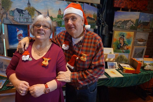 Kunstmaler Rolf Boernert mit seiner Frau. Der Stand mit vielen Langenfelder Motiven ist immer in der Cafeteria.