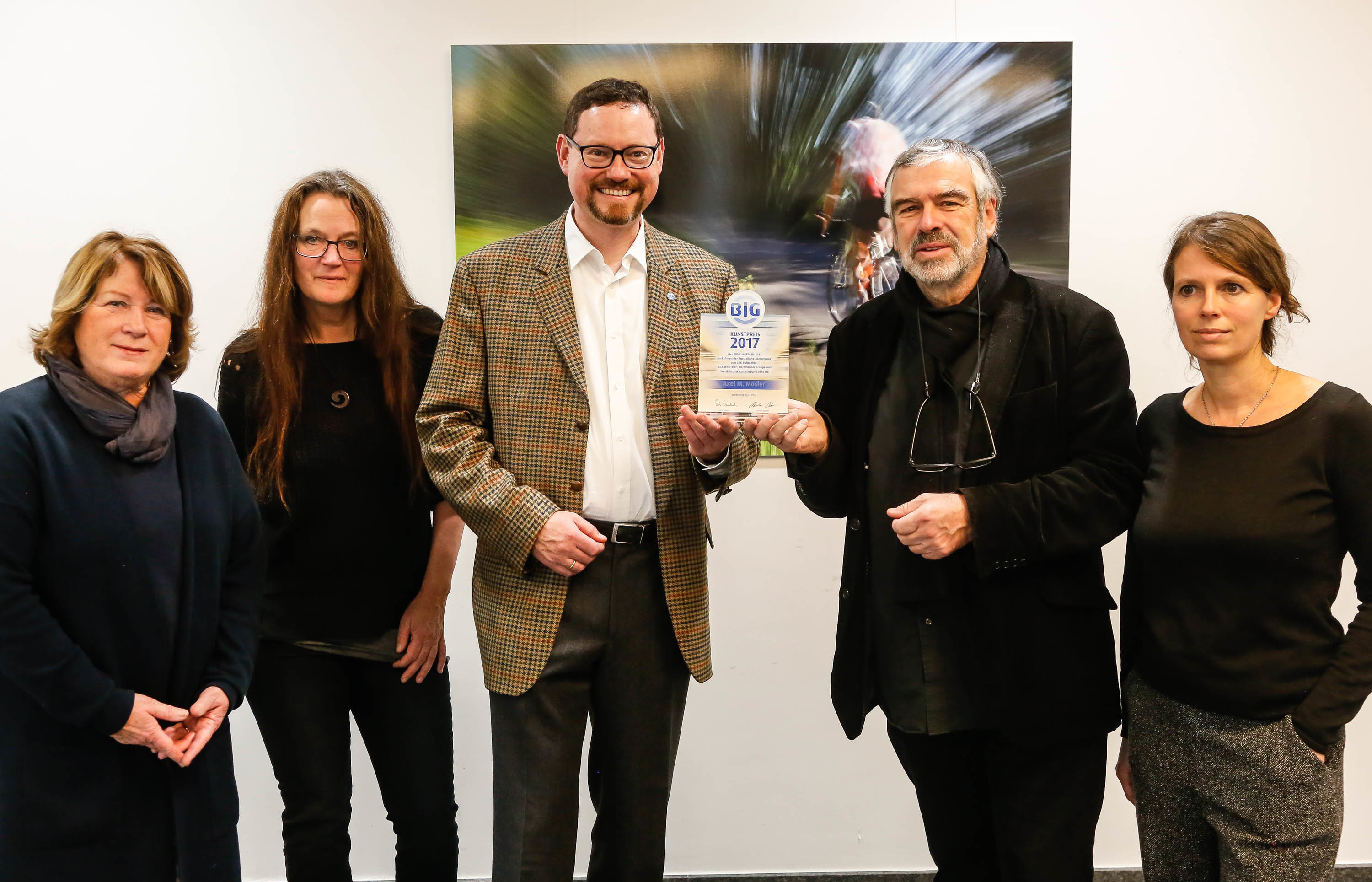 Preisübergabe des BIG-Kunstpreises 2017 mit (von links) Monika Pfeiffer, stellvertretende Sprecherin der vier Künstlerverbände, die drittplatzierte Künstlerin Karla Christoph, Markus Bäumer, stellvertretender Vorstandsvorsitzender der BIG direkt gesund, Preisträger Axel M. Mosler sowie Andrea Hüsken, die zweitplatzierte Künstlerin. Im Hintergrund die ausgezeichnete Fotografie „Bewegung“ des Preisträgers. (Abdruck honorarfrei)