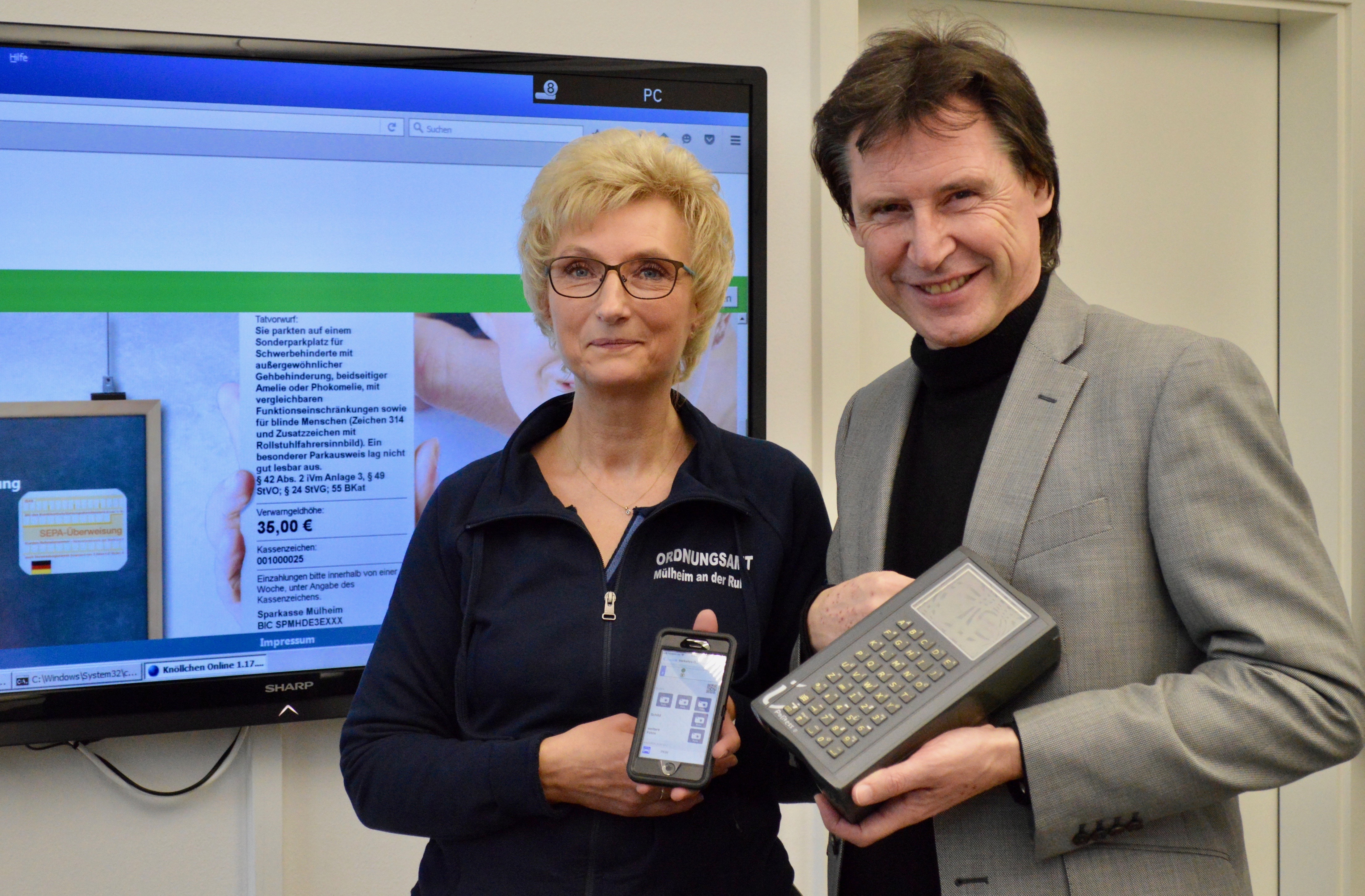 Verkehrsüberwacherin Brigitta Klinkenburg und Stadtdirektor Dr. Frank Steinfort präsentieren den Unterschied zwischen dem alten und neuen Gerät. Foto: RuhrText