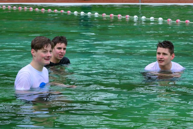 Die Drei hatten eine Wette: Wer kann am längsten im Wasser bleiben. Es vergingen viele Minuten, und schließlich stiegen die drei jungen Männer gemeinsam aus dem Wasser.