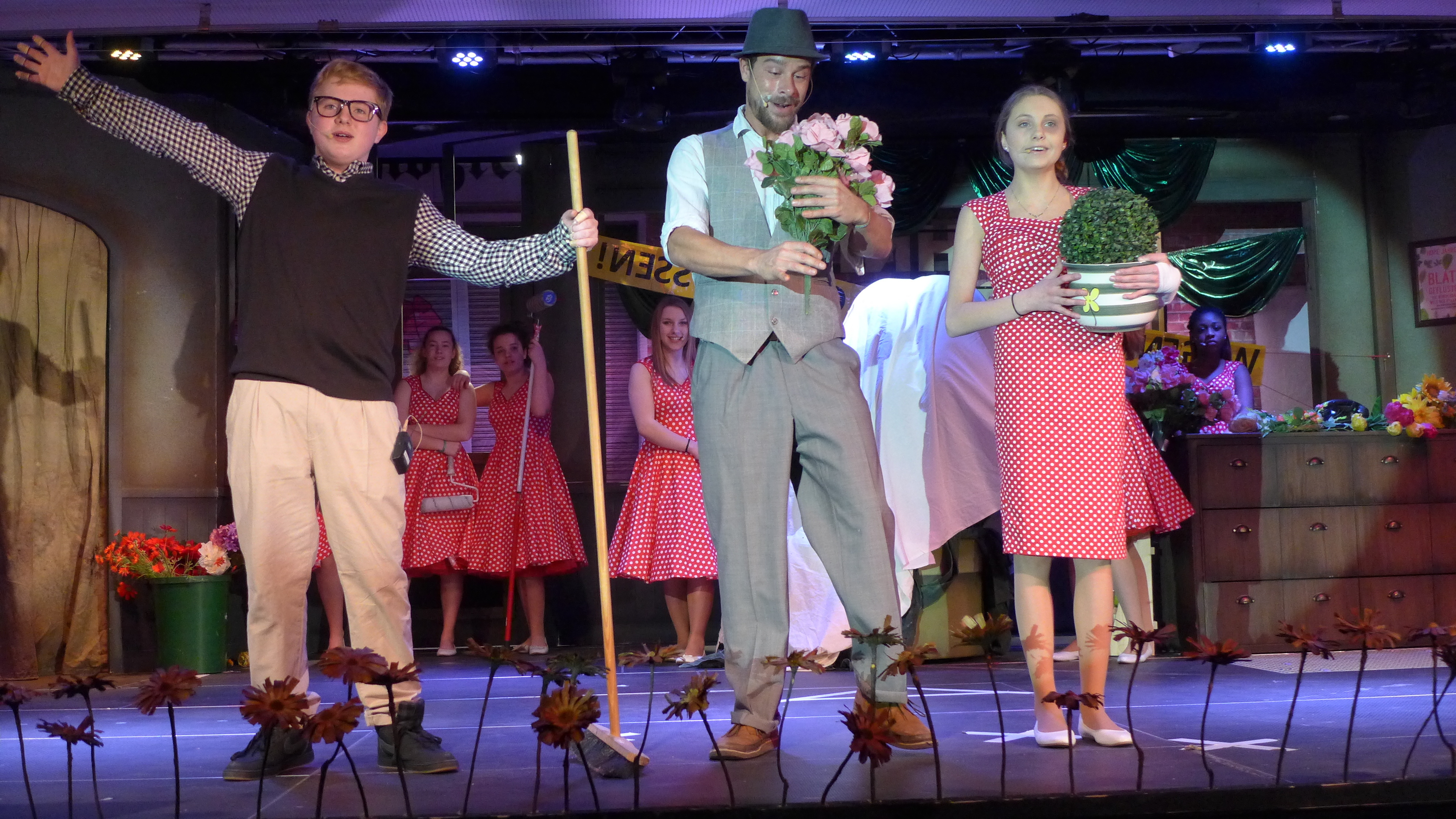 Bei der Generalprobe des Musicals "Der kleine Horrorladen" im Forum der Gesamtschule Saarn: Schüler Joshua Kastner aus der Jahrgangsstufe 9 (als Blumenverkäufer Seymour, Sozialpädagoge Andreas Leitmann (als Ladenbesitzer Mister Muschnick) und Schülerin Xenia Hildebrand aus der Jahrgangsstufe 8 als Blumenverkäuferin Audrey (Foto Emons)