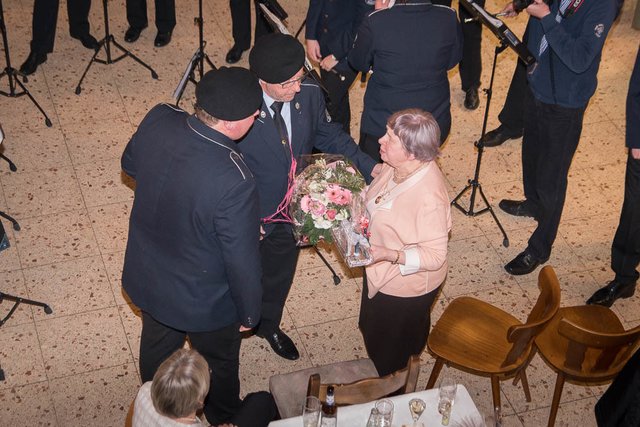 Der Tambourmajor und 1. Vorsitzende Patrick Linz überreicht zusammen mit dem Ehrentambourmajor und Ehrenvorsitzenden Jürgen Linz ein Dankespräsent an Hanna van Gelder