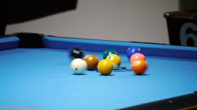 Die Weiße trifft das Rack und die Kugeln springen auseinander