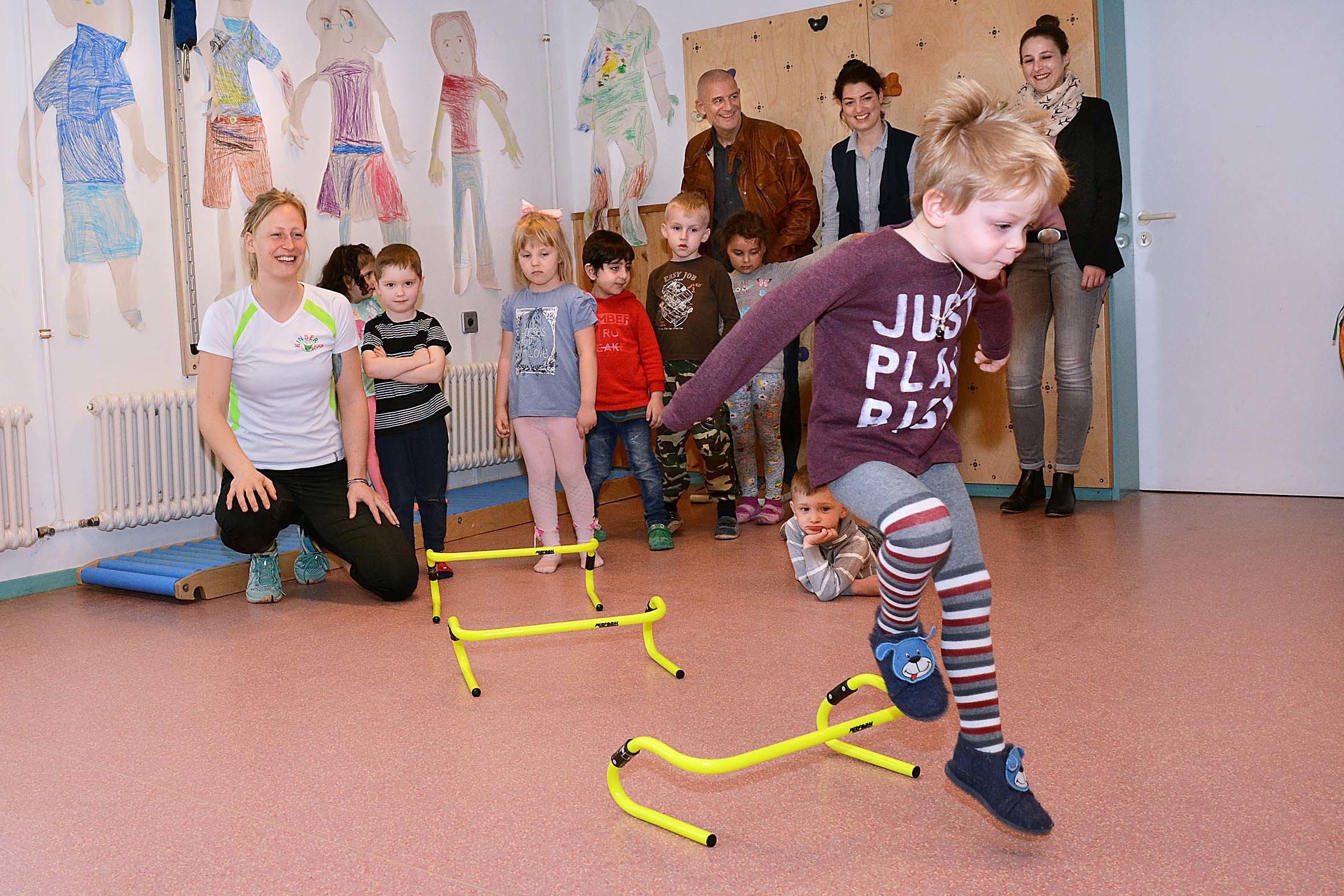 Sportwissenschaftlerin Sarah Reese (l.) motiviert die Kinder, was (v.l.) Bernd Krispin von Kinderglück, Erzieherin Gianna Gerl und Meike Goldhagen von der BIG freut.