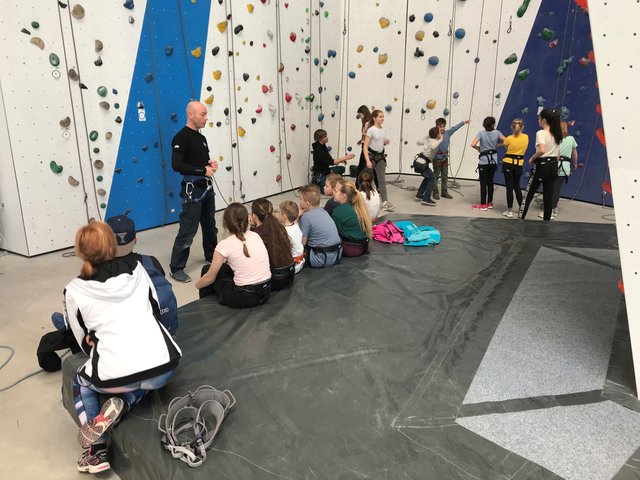 Hier hören die Kinder konzentriert den Ausführungen des Trainers in der Kletterhalle zu.