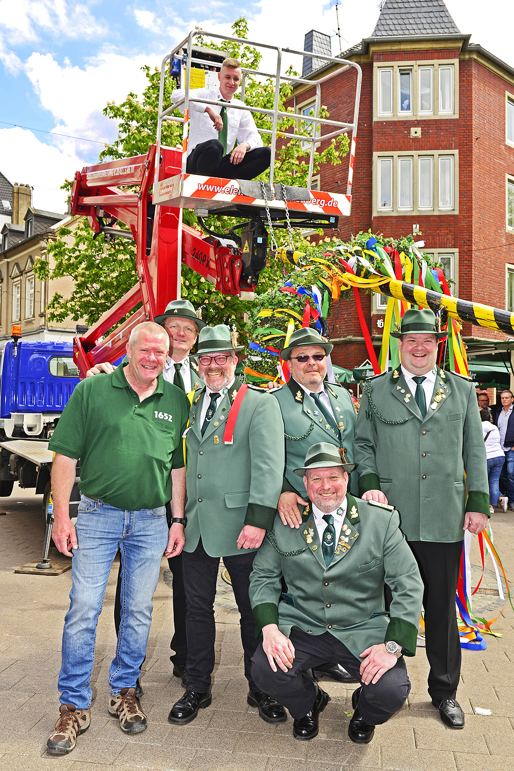 Fertig zum hochhieven: Der Maibaum samt montiertem Maikranz steht bereit und kann jetzt mit dem Hubsteiger von Jörg Schwalvenberg hochgezogen- und in die Bodenhülse gehievt werden. Anschließend belohnten die umstehenden Passanten die Aktion mit Applaus. Foto: Kariger