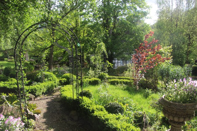 Im Garten der Sattlers in Hattingen führen verschlungene Wege durch Pergolen, vorbei an historischen Fachwerkgebäuden, Obstgarten und Kräuterbeeten, zum Teich mit Meditationsecke.Fotos (2): Laura Kämper
