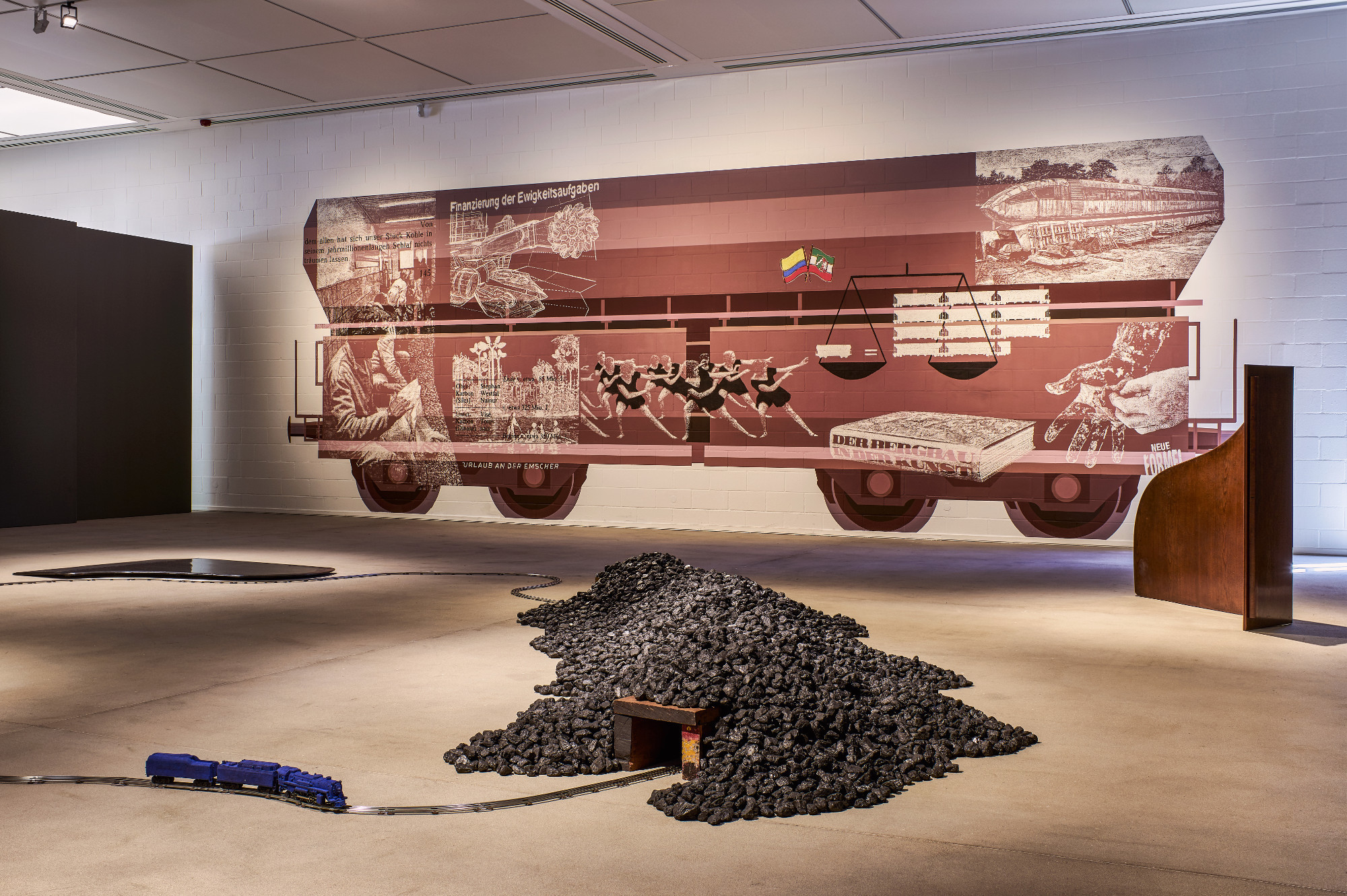Eine Impression aus der Ausstellung „Reichtum: Schwarz ist Gold“. Im Vordergrund: David Hammons ("Chasing the blue train"). Im Hintergrund: Jürgen Stollhans ("Mit schlagartiger Schwerkraftentladung"). Foto: Dejan Saric