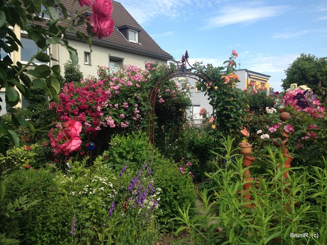Im hinterem Teil des Gartens wieder ein Rondell - mit hoch gestapelten Blumentöpfen im Zentrum und natürlich wieder Rosenbögen und tollen Stauden...