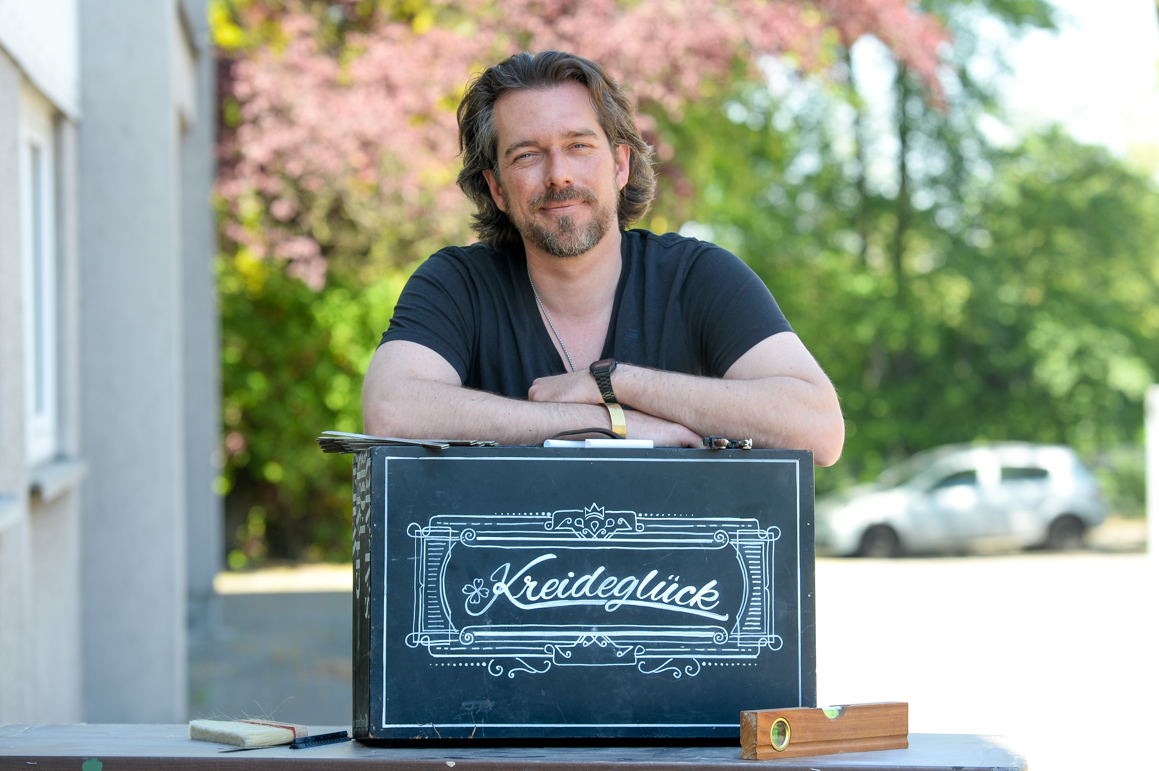 Marko Kocks malt Kreideschilder für seine Kunden.