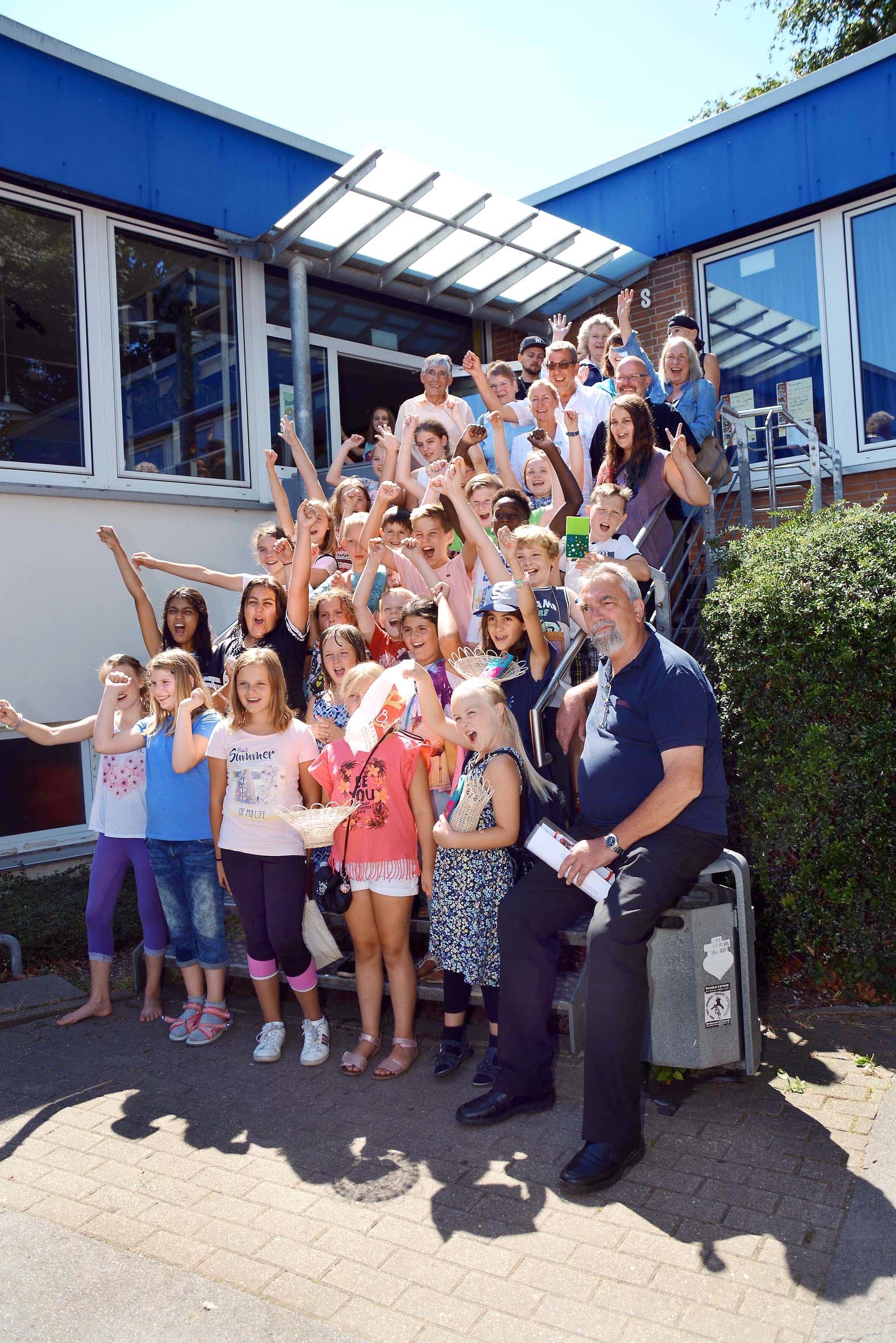 Zum Start der Ferienspiele in Wickede jubeln Kinder, Mitarbeiter und Unterstützer vor der Jugendfreizeitstätte Bremmenstraße.