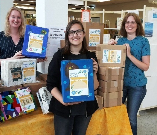 Bibliotheksmitarbeiterin Silke Becker (v.l.), Praktikantin Jana Purr und Bibliotheksleiterin Kristina Truß freuen sich die Überraschungskisten wieder anbieten zu können.