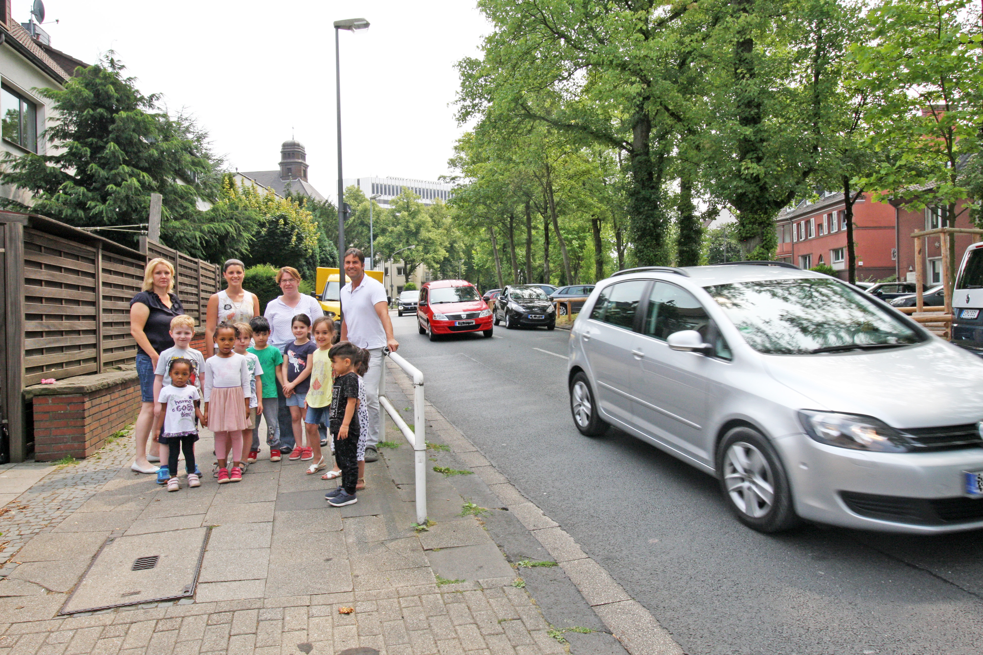 Vor dem VKJ-Kinderhaus "Sterntaler" an der Ruhrallee 75 gibt es immer wieder Probleme mit der unübersichtlichen Situation und den hohen Geschwindigkeiten des Autoverkehrs. Julia Lörks und Irene Syré vom Elternrat der Kita (hintere Reihe, 2. u. 3. v.l.) sowie Kinderarzt Dr. Achim Rode und Kinderhaus-Leiterin Yvonne Möllers (l.) hoffen auf eine Verbesserung der Situation. Foto: VKJ