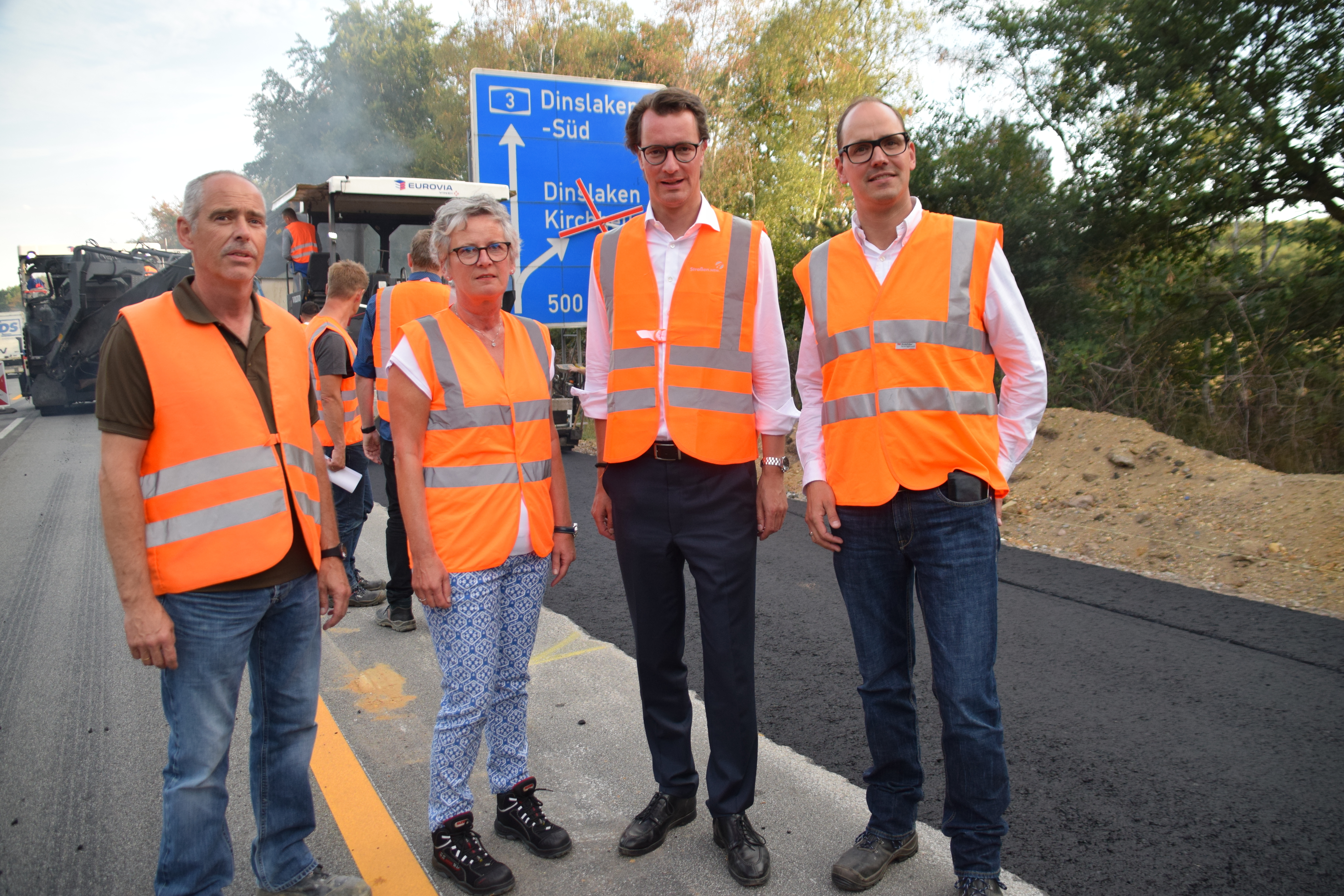 Verkehrsminister Hendrik Wüst (2.v.r.) besichtigt mit führenden Mitarbeitern der Firma EURIVIA Vinci Teerbau sowie Elfriede Sauerwein-Braksiek, Direktorin des Landesbetriebes Straßenbau NRW, die Baustelle an der A3.