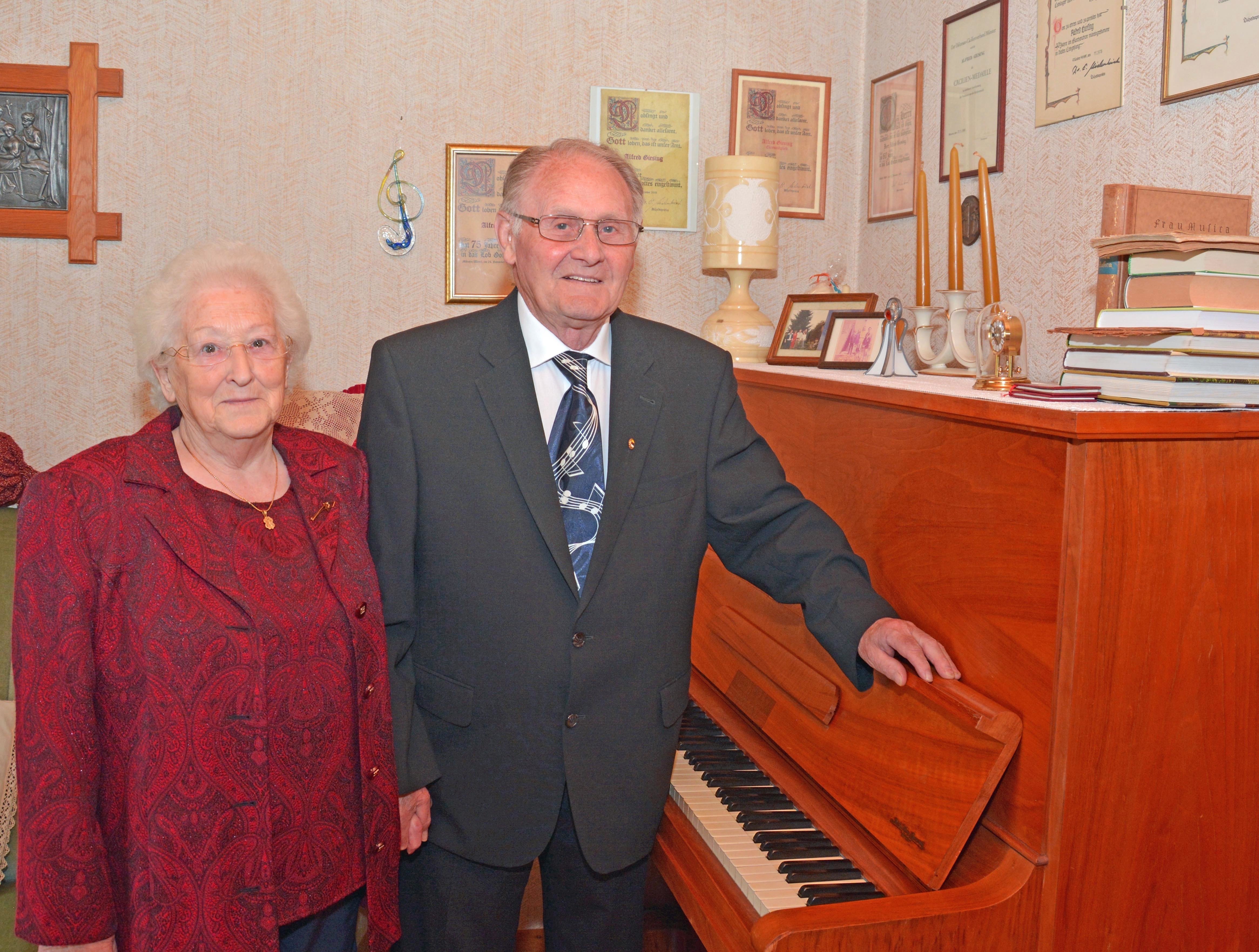 Urkunden und die Cäcilienmedaille über dem Klavier dokumentieren, wie lange sich Albert Giesing schon für den Chor einsetzt. Seine Frau Gertrud unterstützt ihn dabei.