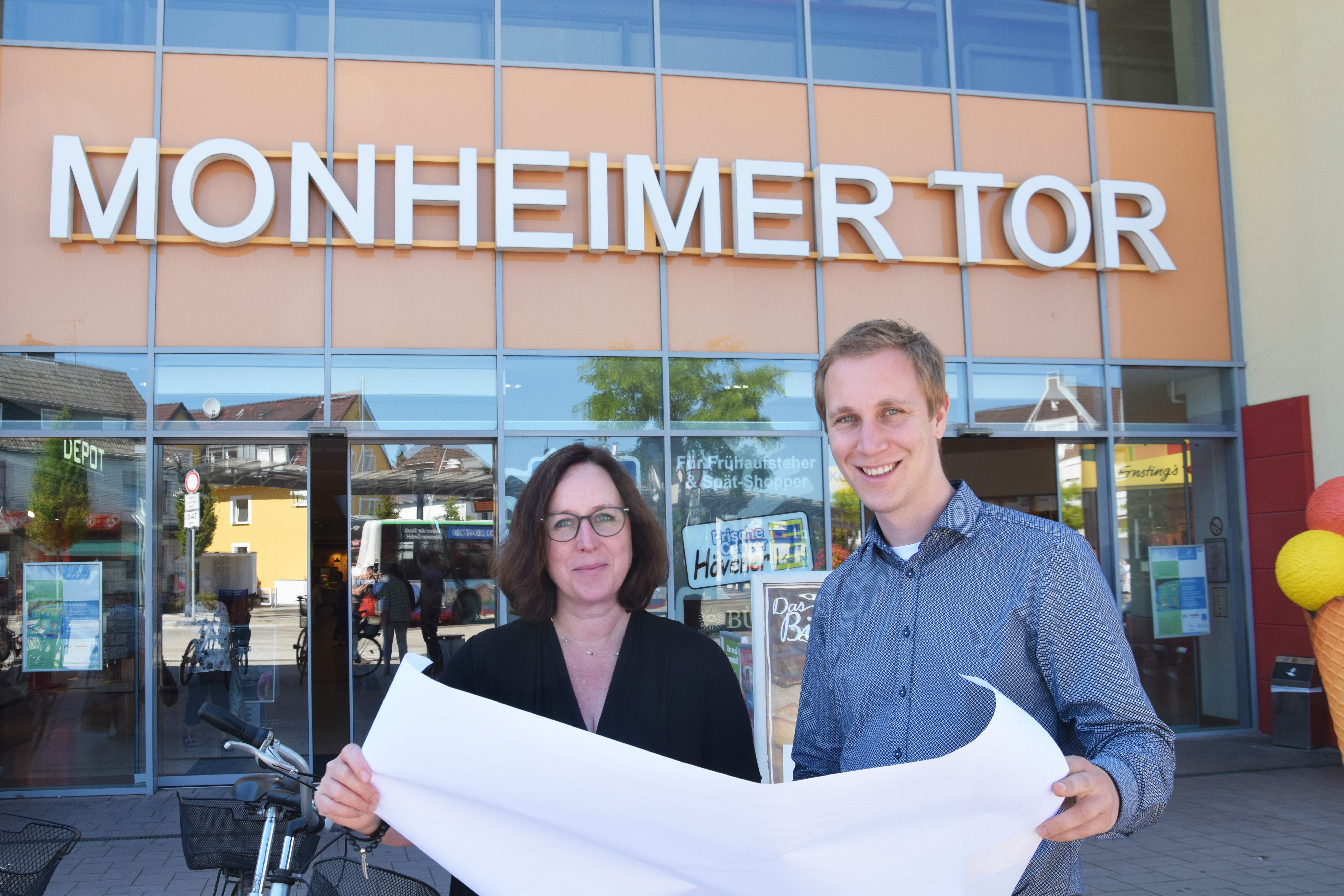 Monheimer_Tor.JPG
BU: Bürgermeister Daniel Zimmermann und Isabel Port, Geschäftsführerin der drei städtischen Tochtergesellschaften Monheimer Einkaufszentren I¸ Monheimer Einkaufszentren II sowie der Baumberger Einkaufszentrum GmbH, wollen das Monheimer Tor zu einem echten Eingangstor in Monheims Mitte entwickeln und zugleich zu einem verbindenden Element zwischen Stadtzentrum und Berliner Viertel gestalten.