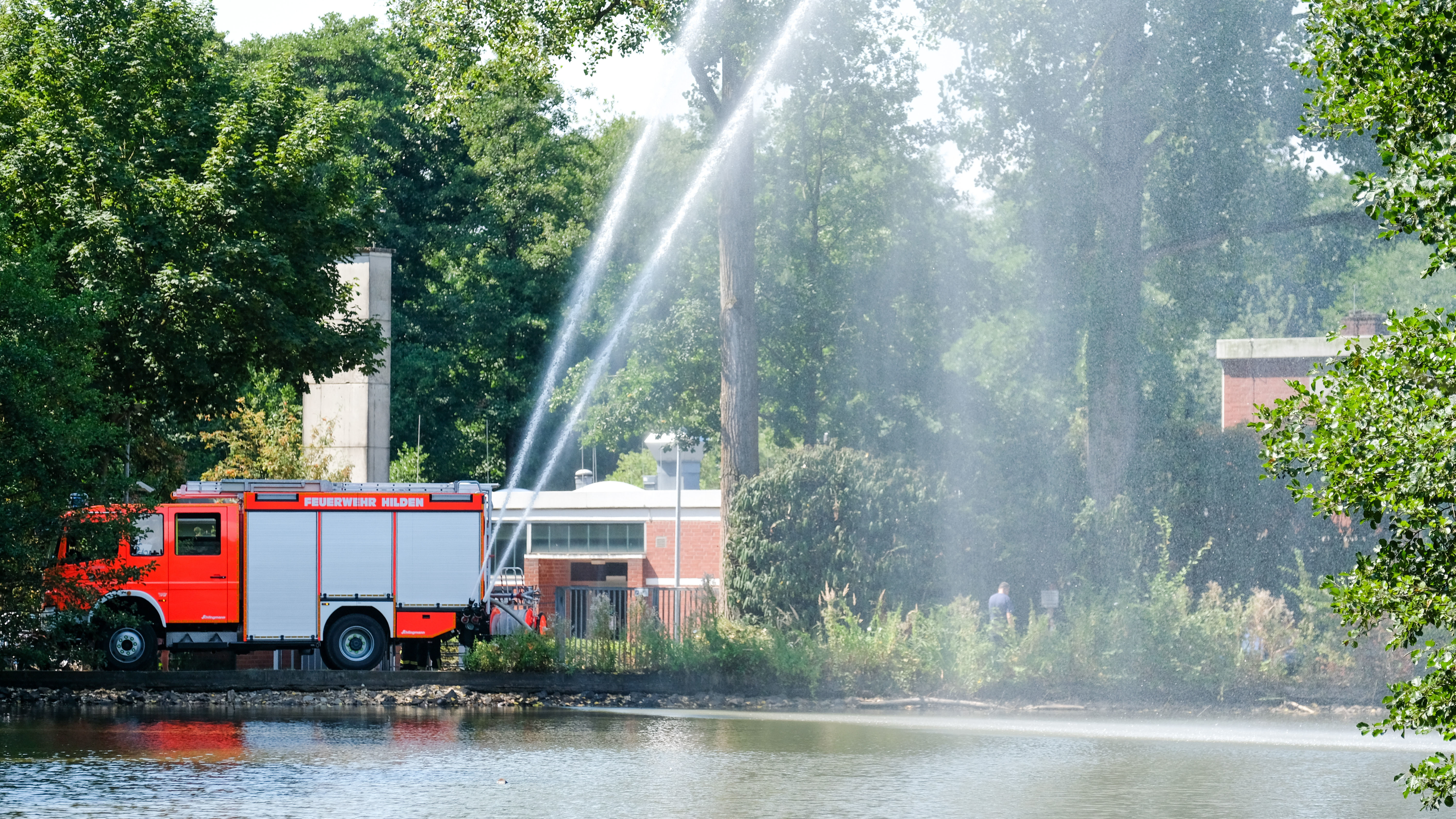 Drei Feuerwehrleute sorgen für Frischwasser und Sauerstoff im Stadtwaldteich. Fotos: Stadt Hilden