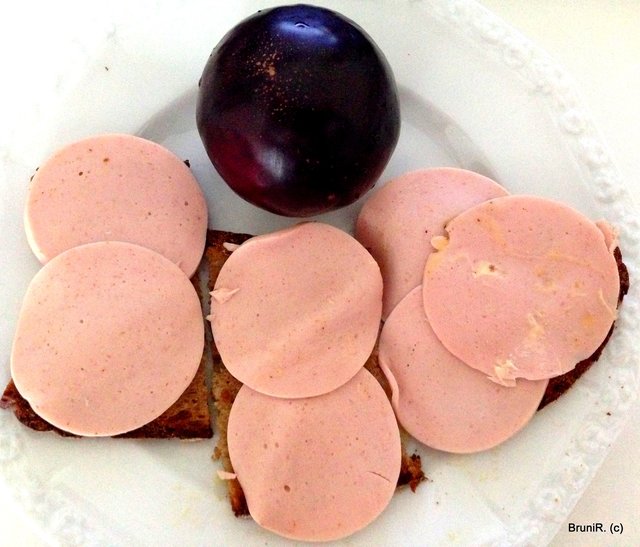 Fleischwurst auf Brot mit einer Pflaume