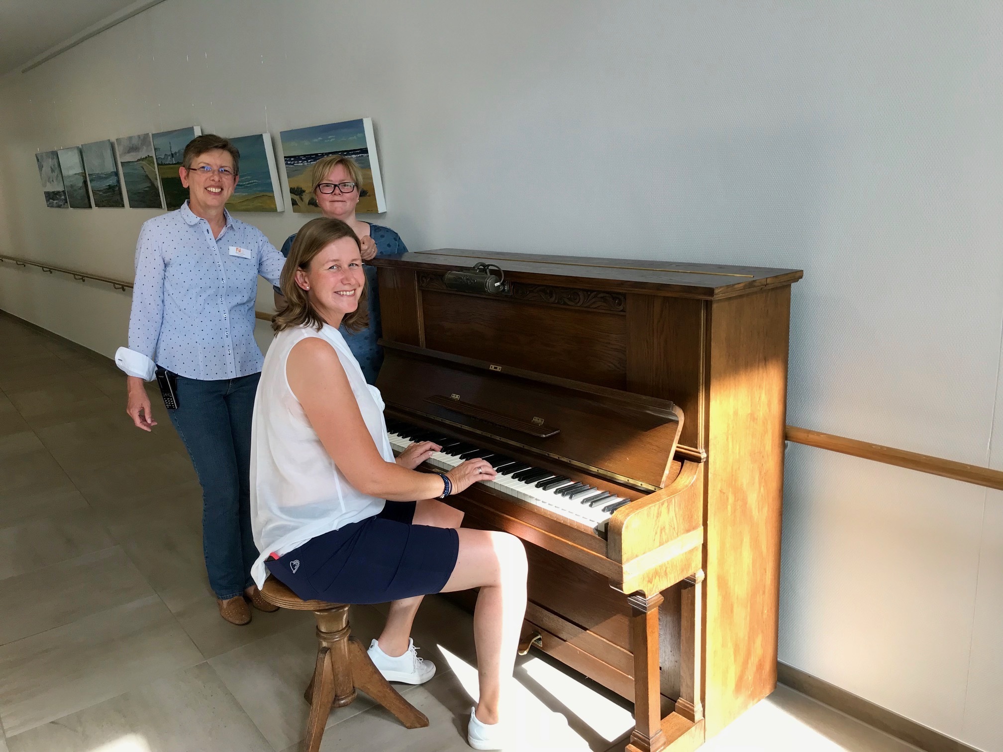 Dörte Knauf (am Klavier) hat dem Hospiz das Klavier gespendet und persönlich übergeben. Hospizleiterin Marion Eichhorn (l.) und die stellvertretende Leiterin Ina Schulz (r.) nahmen das Instrument hoch erfreut in Empfang.