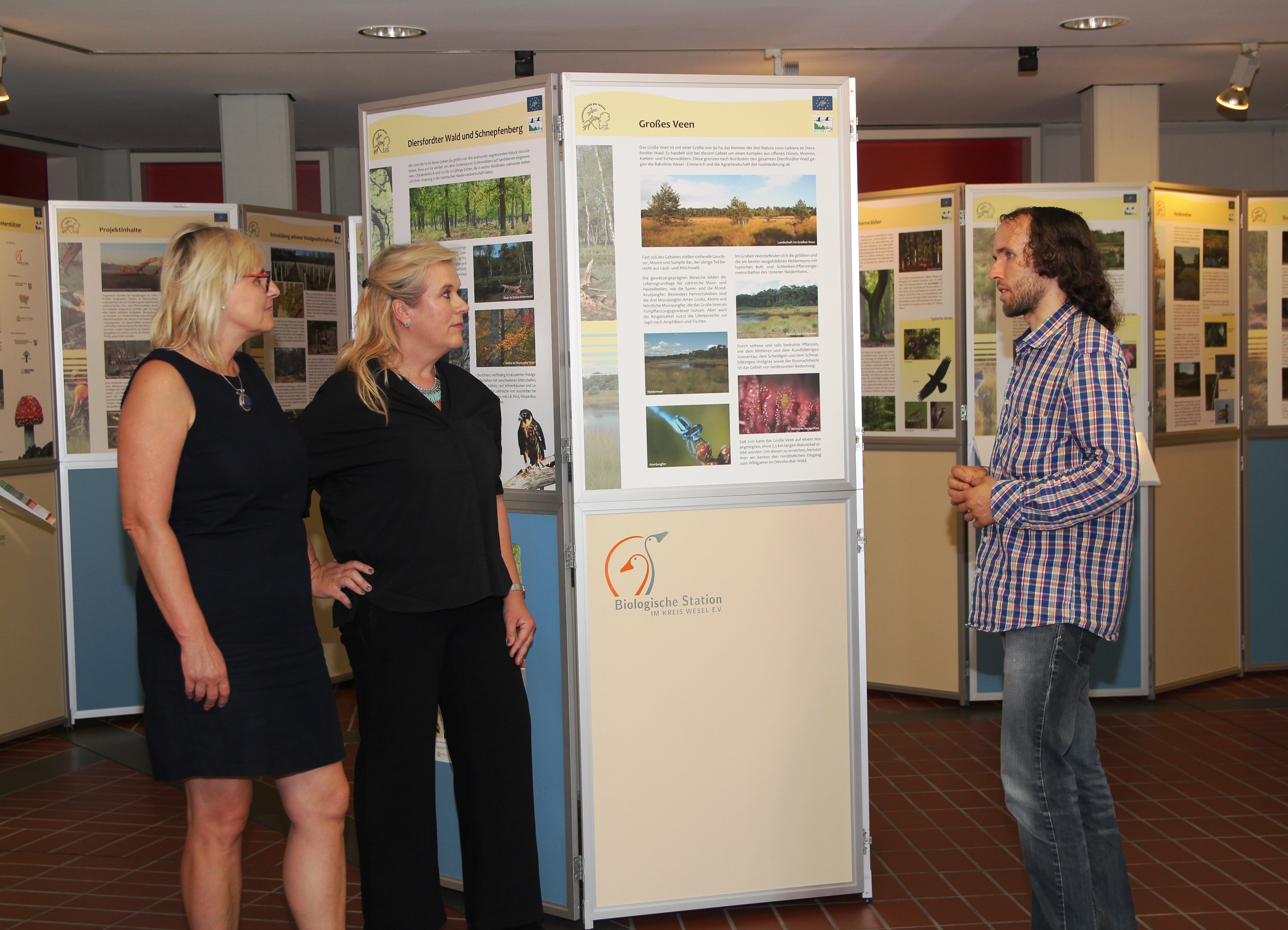 Thomas Trail von der Biologischen Station Wesel erläutert Rita Nehling-Krüger und Dietlind Dellbrügge von der Stadt Hamminkeln Einzelheiten der in der Wanderausstellung vorgestellten Naturschutzprojekte.