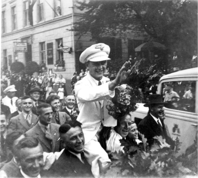 Aus dem Lachen und Winken kommt Willy Kaiser kaum noch heraus, als er in seiner weißen Sportleruniform auf Schultern durch die Innenstadt getragen wird. Foto: Archiv