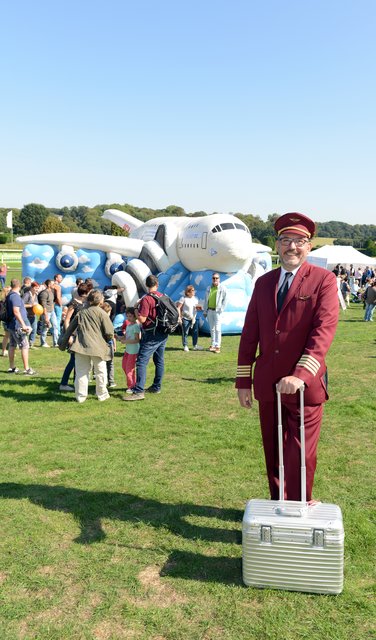 Kinder-Flughafen-Fest auf der Galopprennbahn in Grafenberg. Flugkapitän (Schauspieler) vor der Hüpfburg.