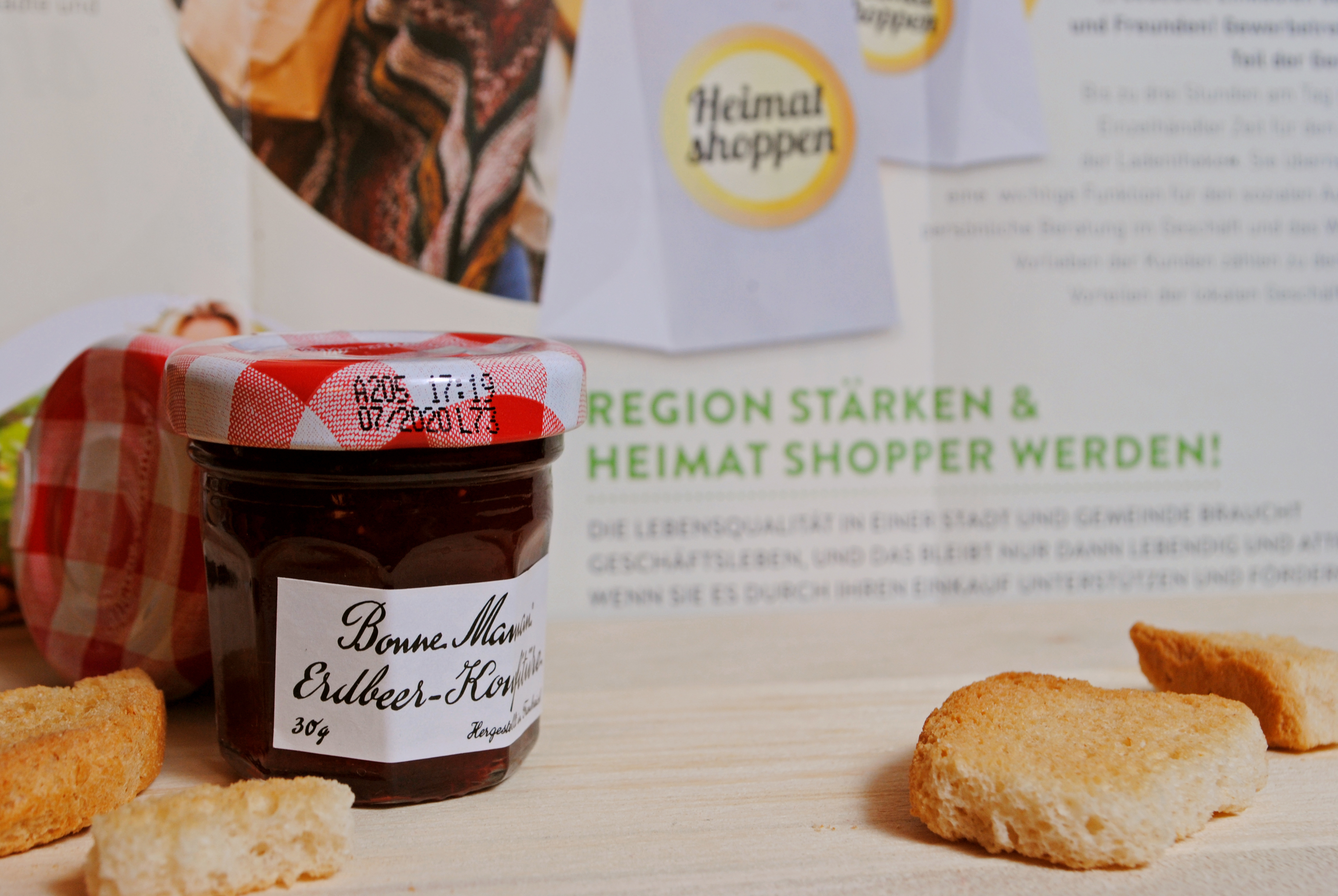 Süße Idee: Marmelade zum Heimat shoppen (Zuhause mit Flyer und Zwieback zu einem Stillleben arrangiert)