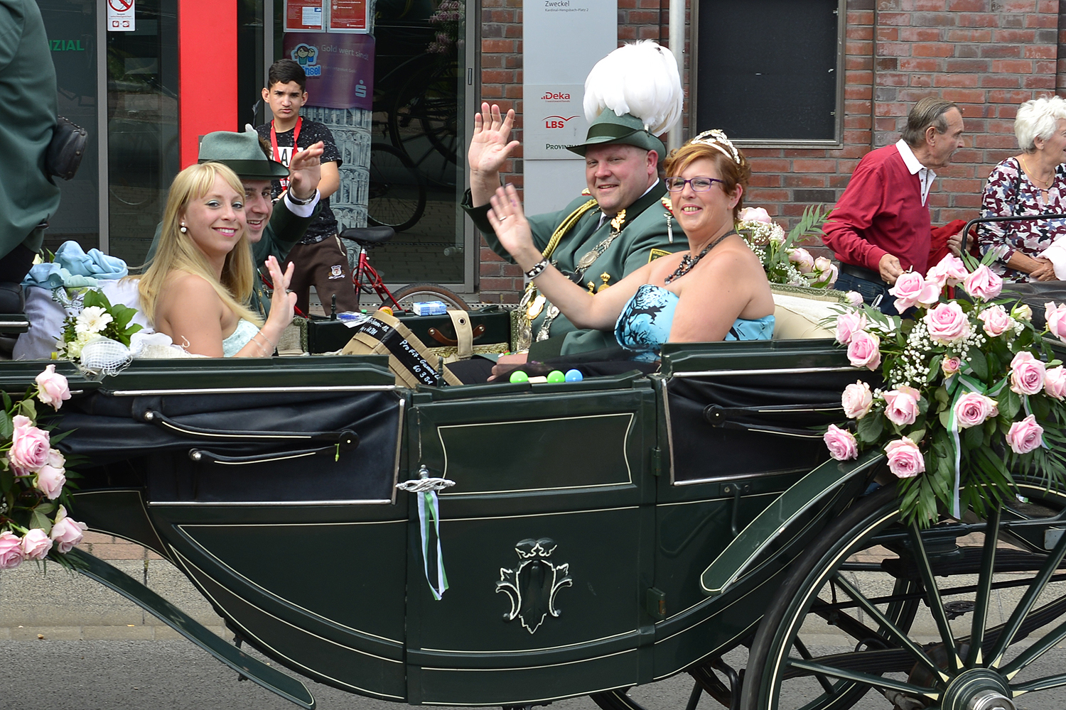 Das Kaiserpaar der Zweckeler Hubertus-Schützen, der Vorsitzende des Vereins u. Kaiser André I. Misch mit Nicole I. Schrotmann, bestens gelaunt in der mit Rosen geschmückten Kutsche, umfahren den Kreisverkehr am Kardinal-Hengsbach Platz in Zweckel. Foto: Kariger